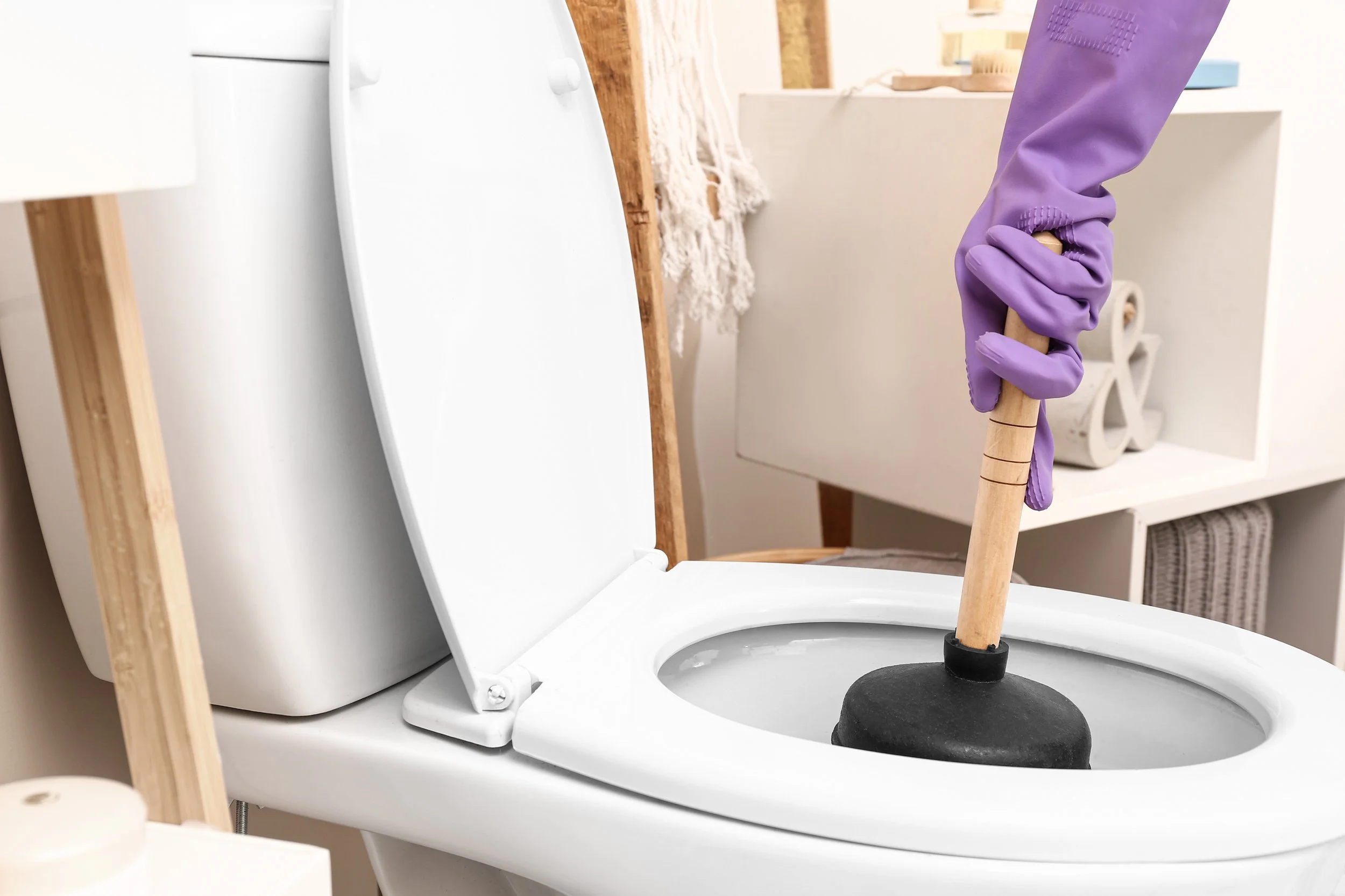 Unclogging a clogged toilet with a plunger