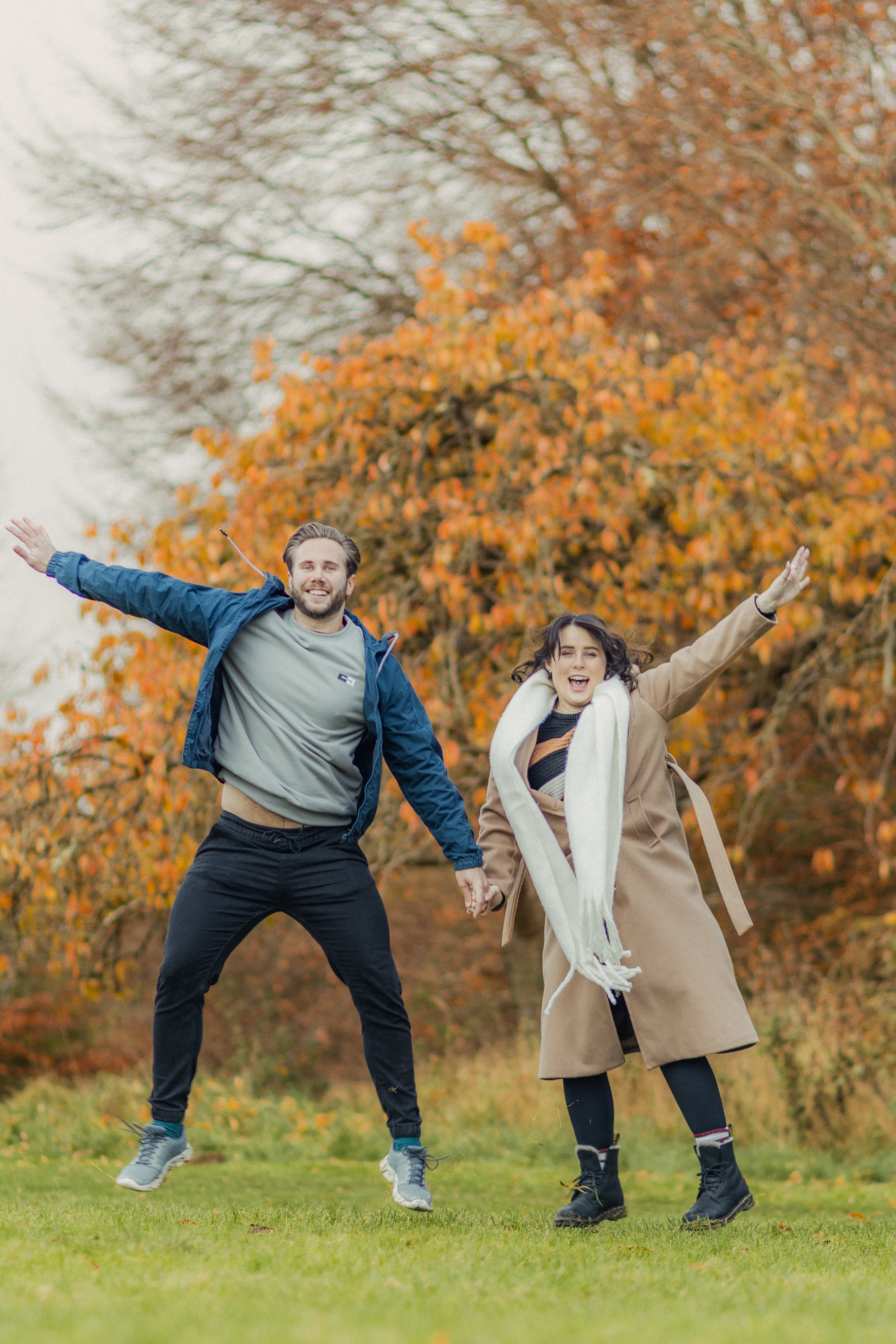 Excited couple photographed in Brighton surrounded by Autumn trees