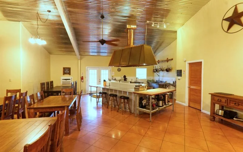 A cozy kitchen and dining area with wooden furniture, a large kitchen island, and decorative wall accents.