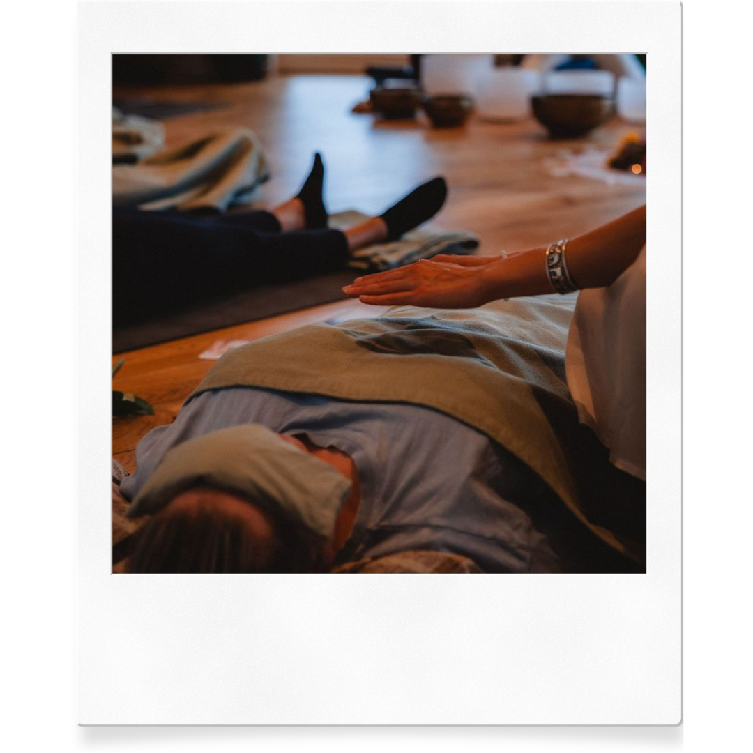 People practicing meditation or mindfulness on mats in a dimly lit indoor space.