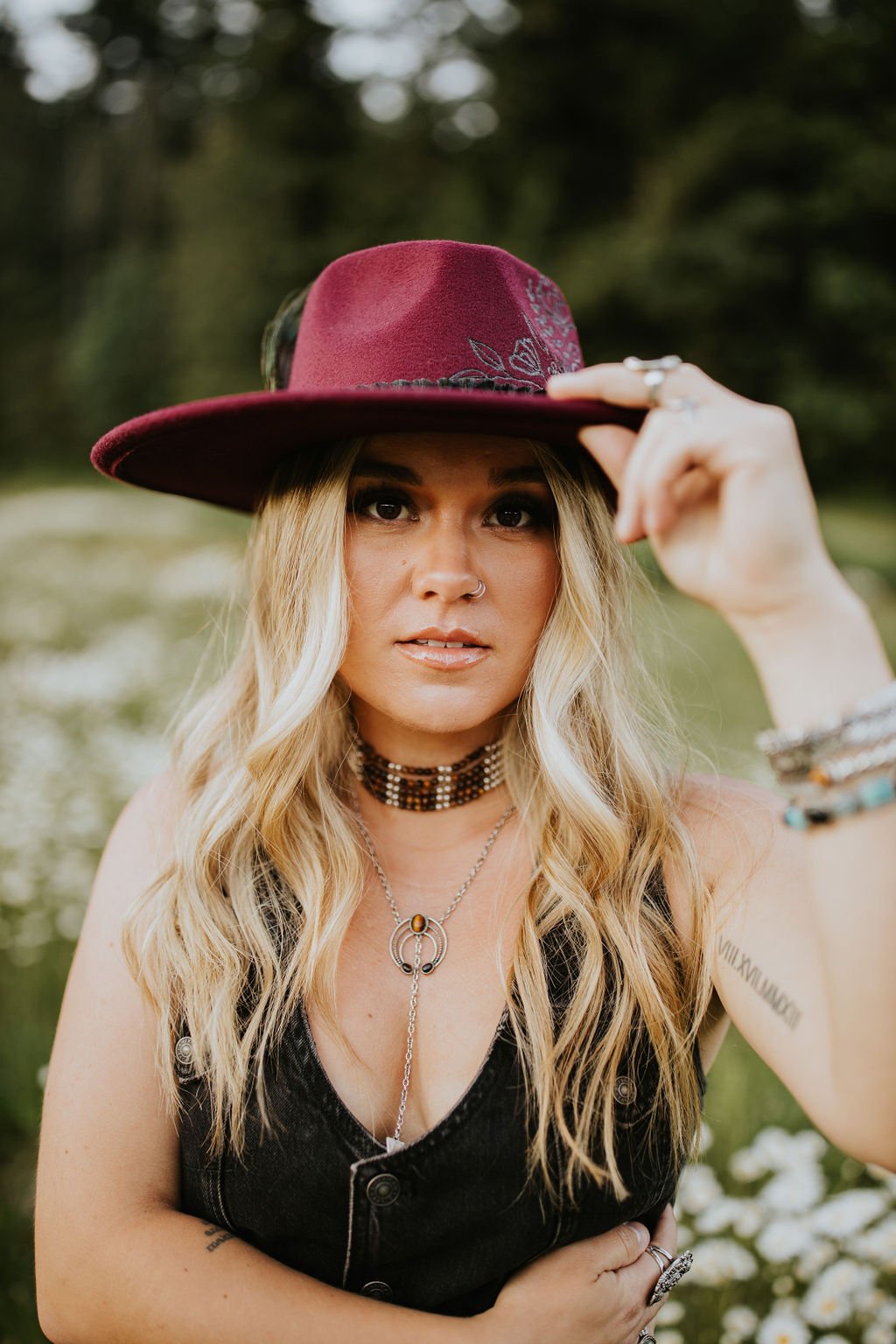 Woman with long dimensional blonde hair wearing a western-style hat outdoors