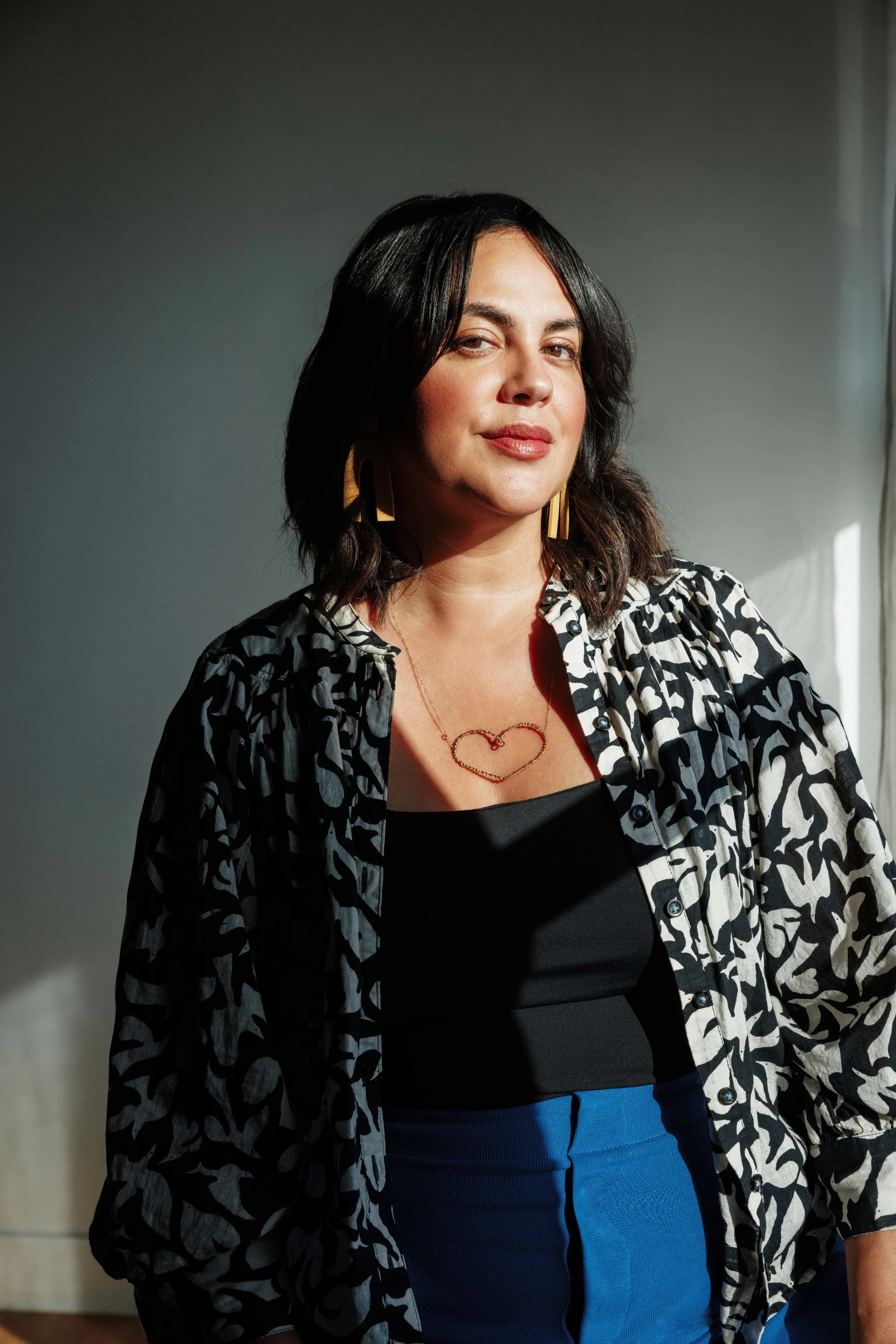 Nic Roc Strategic Advisor and Brand Strategist standing near a window and sunlight is casting upon her
