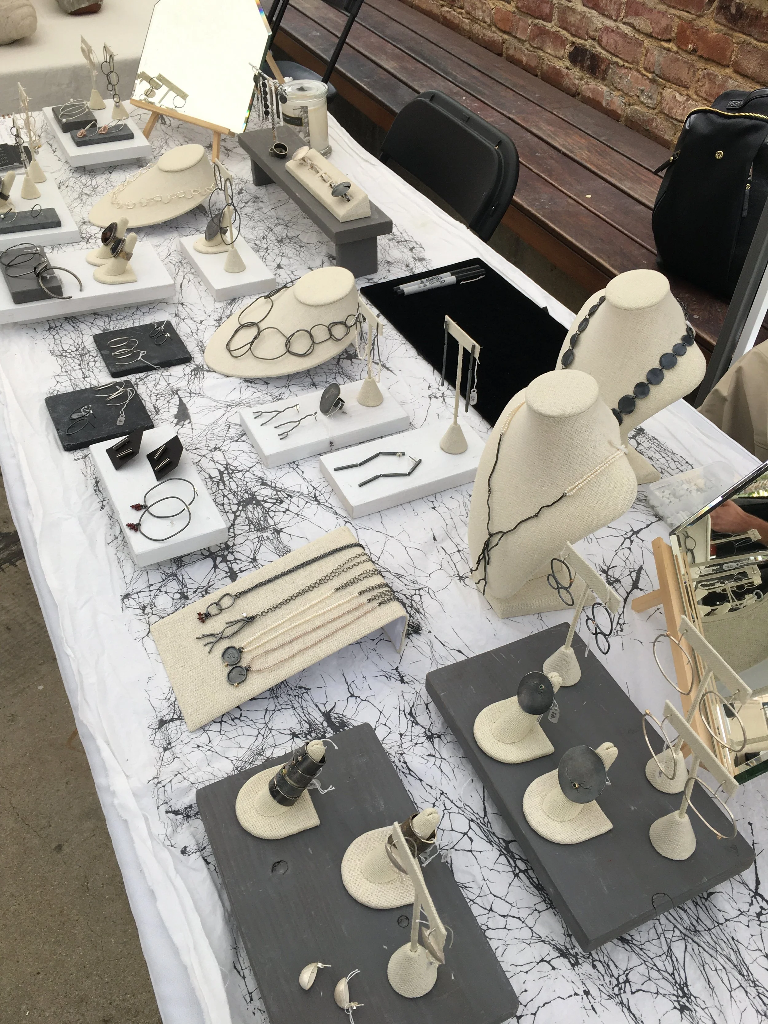 jewelry made by charmaine vegas for bless the theory on display table at craft contemporary holiday marketplace