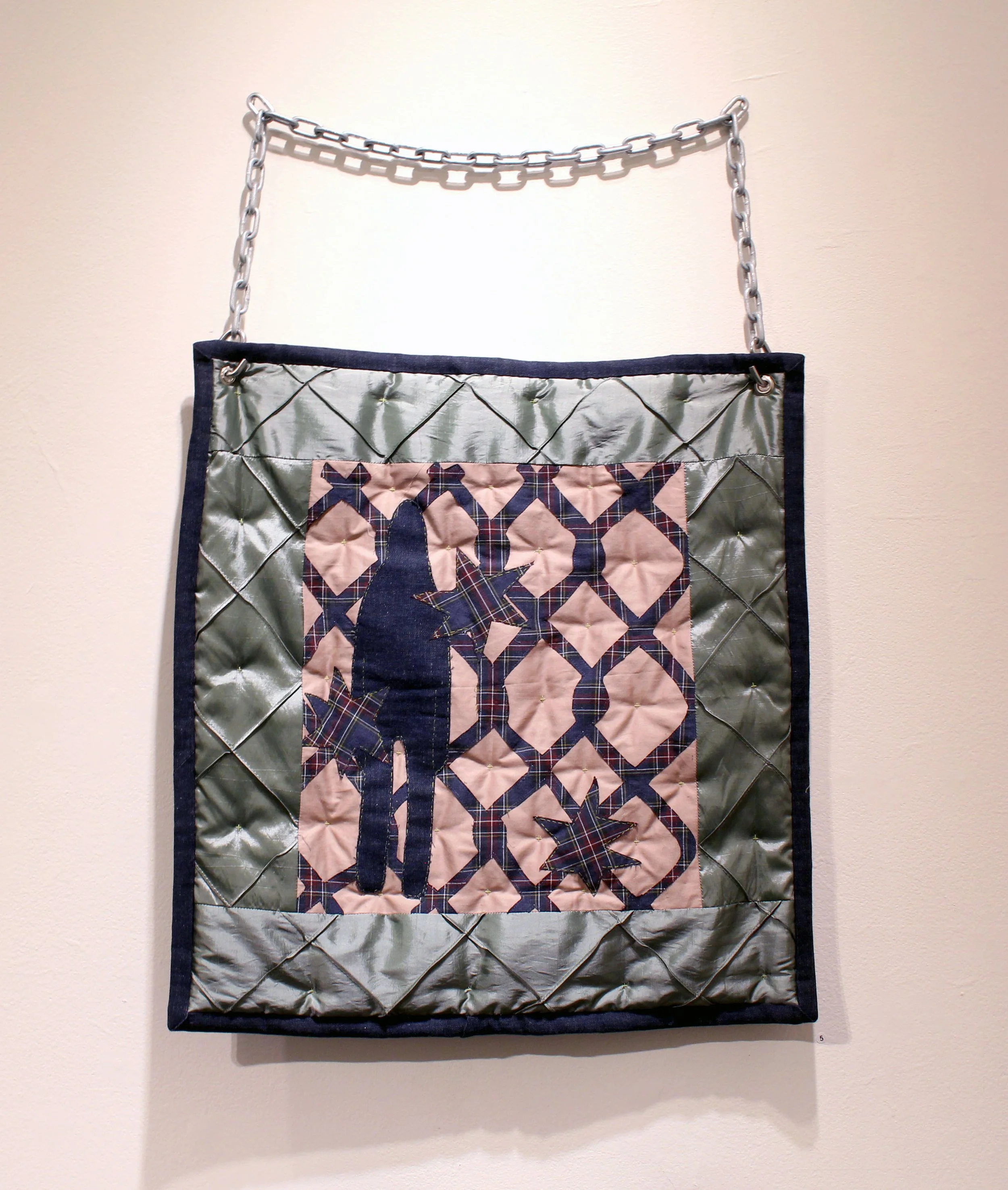 "When the System Breaks", found fabric, embroidery, machine sewing, grommet, zinc chain, 20" x 20", 2026 