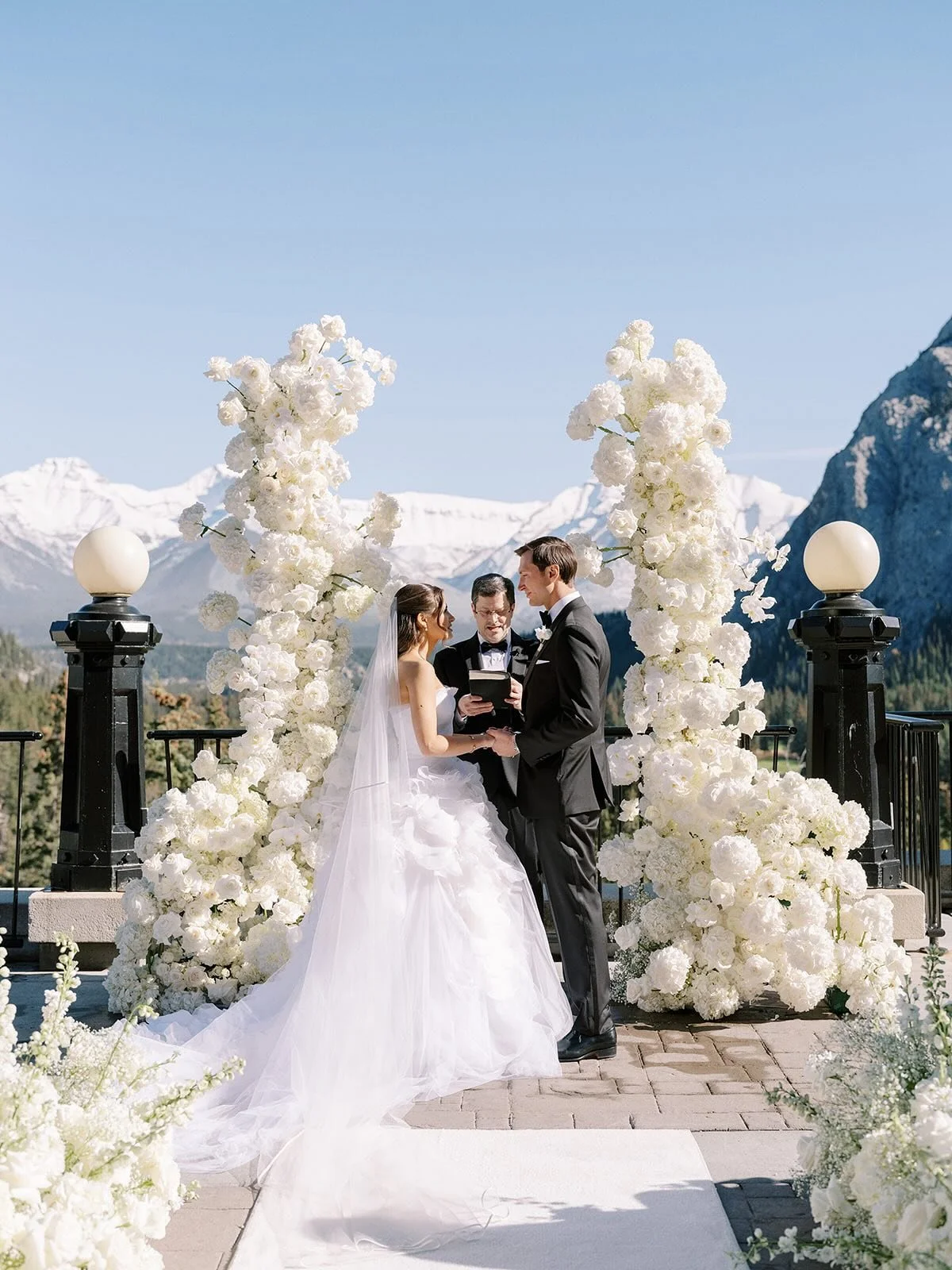Every ceremony structure should be at least 9ft tall. This design by @jodymcbeath and @flowerartistry was amazing, so grand and so visible, not hidden by the amazing dress. But it also framed the mountains perfectly!⁠
Also the most perfect dusting of