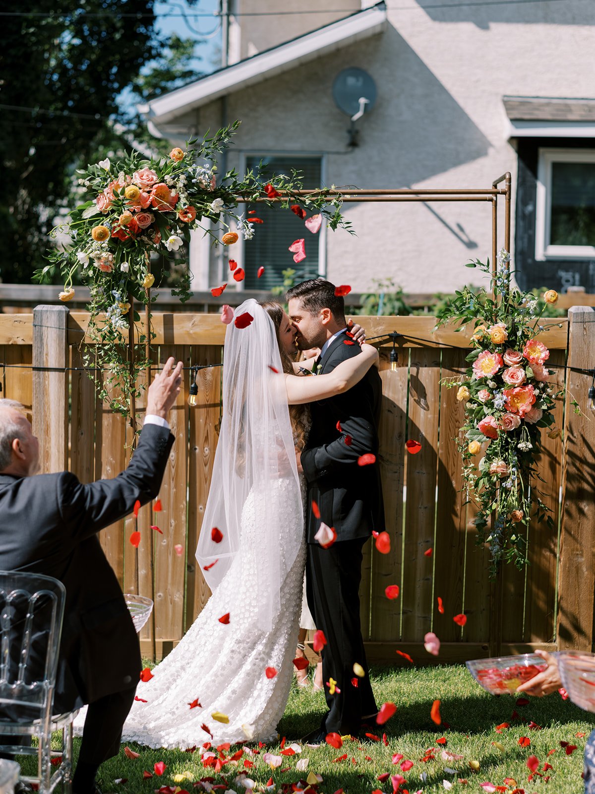 first kiss with petal toss at intimate backyard wedding in edmonton