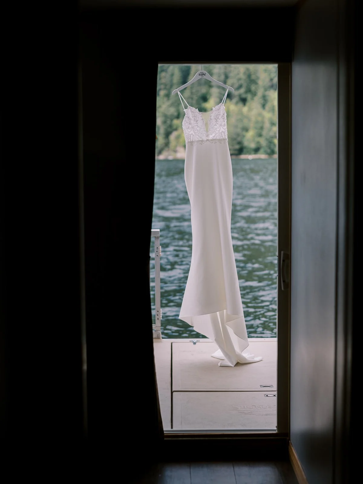 wedding dress hanging in the back of a boat