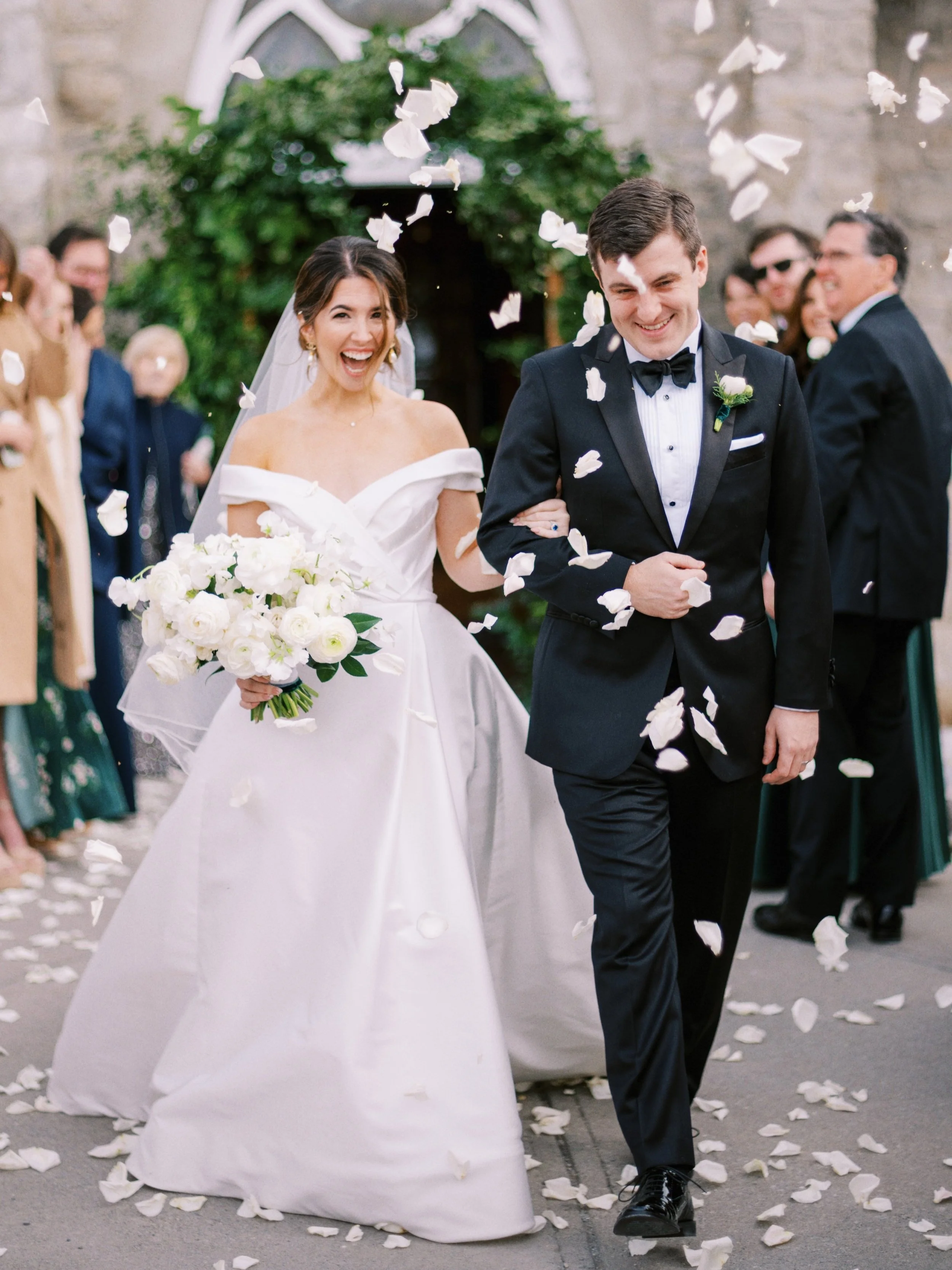 classic bride and groom celebrate after ceremony with flower petal toss