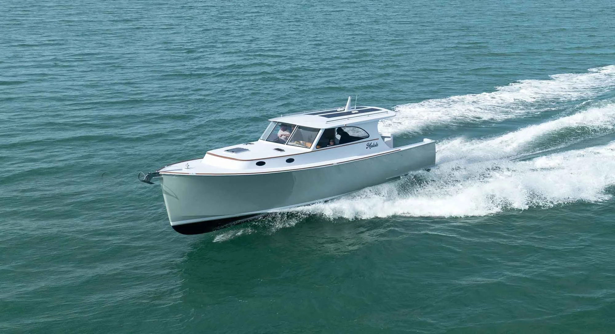A white motorboat speeding through the water, creating a wake behind it.