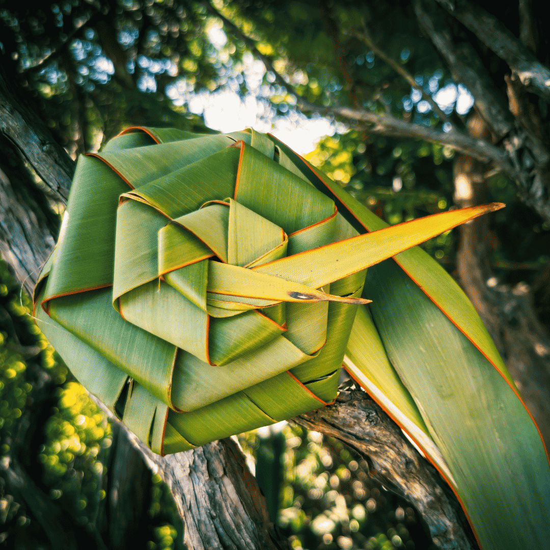 flax weaved into a spiral with trees in the background.