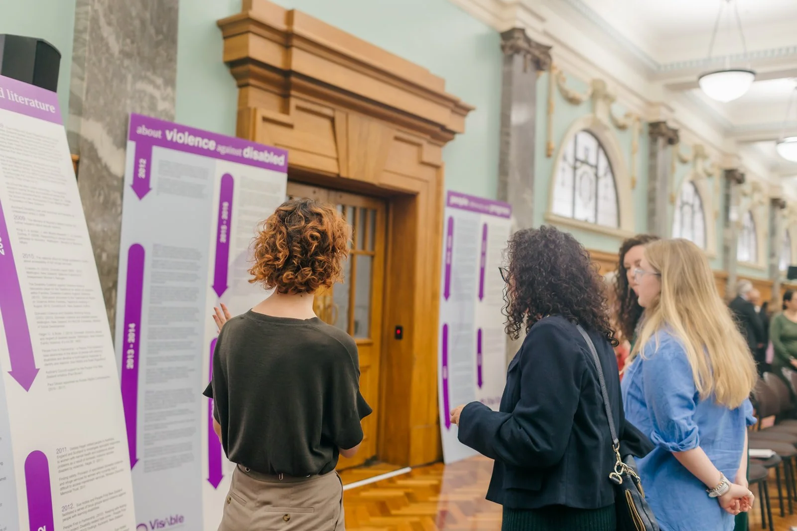 This is an image of one of the VisAble team members showcasing the timeline of work that has led to the launch of VisAble at the parliamentary launch of VisAble
