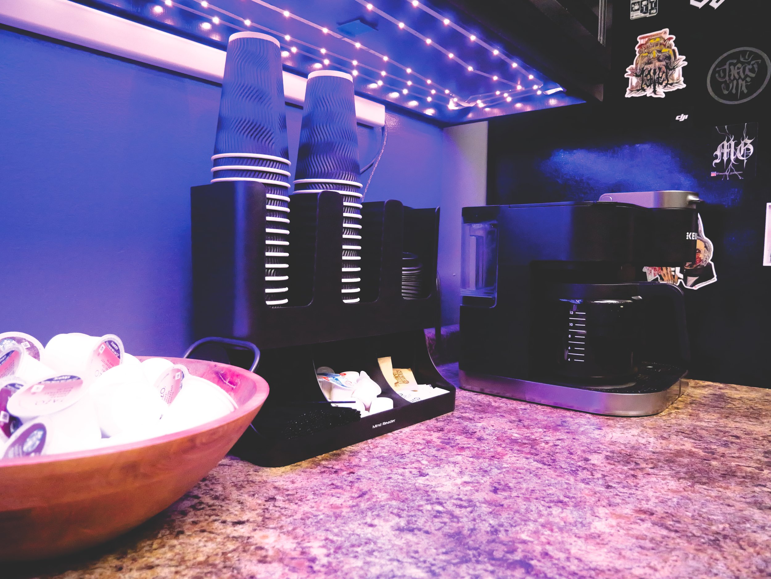 Coffee station with machine, paper cups, and pods