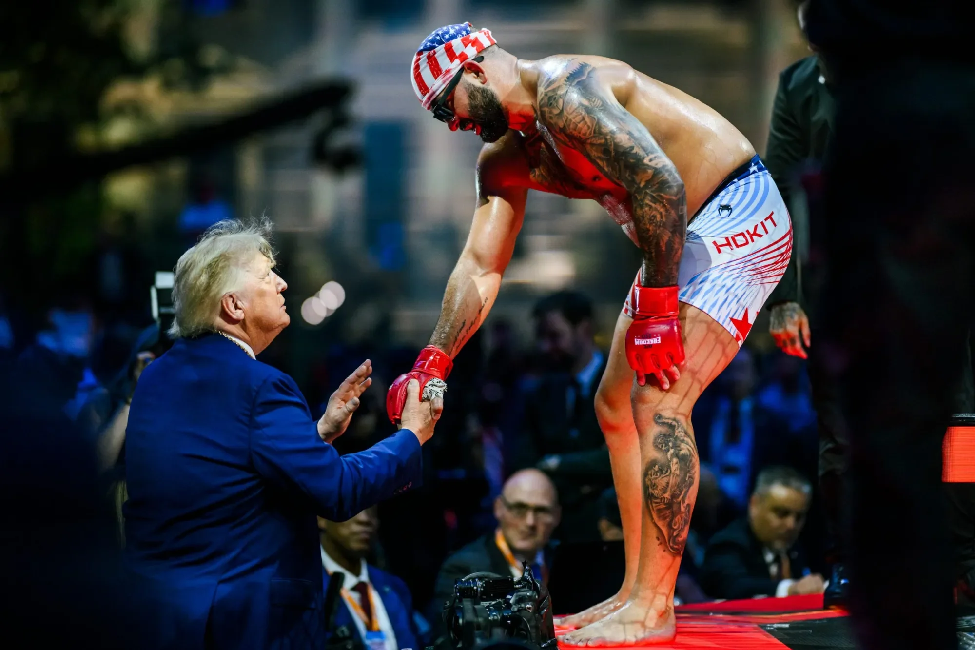 Fighter Hokit shaking hands from the cage with Donald Trump