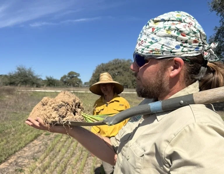 Clay balancing a shovel of dirt on his shoulder.