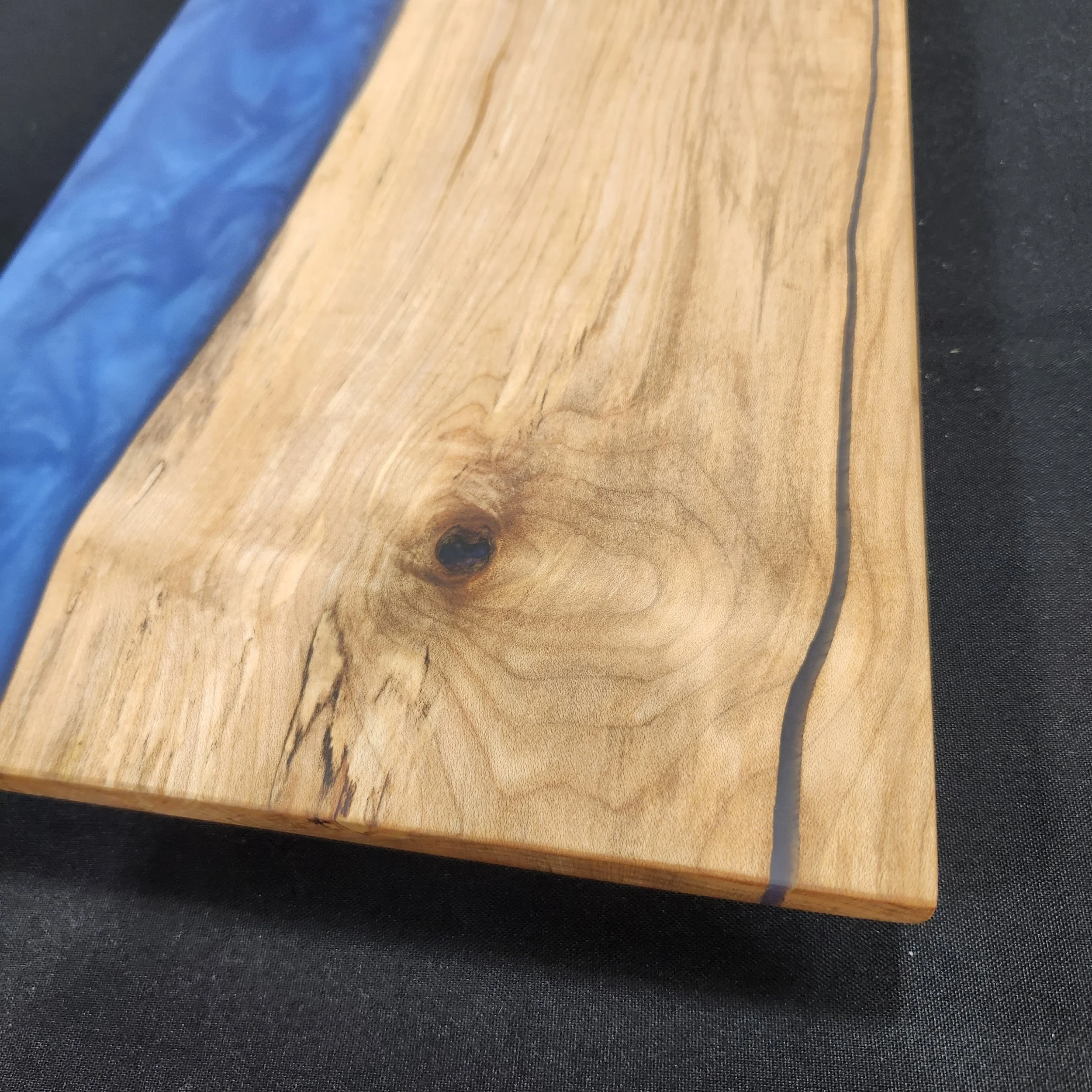 Close up of end of 16 x 9 Maple Wood Epoxy Charcuterie Board with Deep Blue Sea epoxy