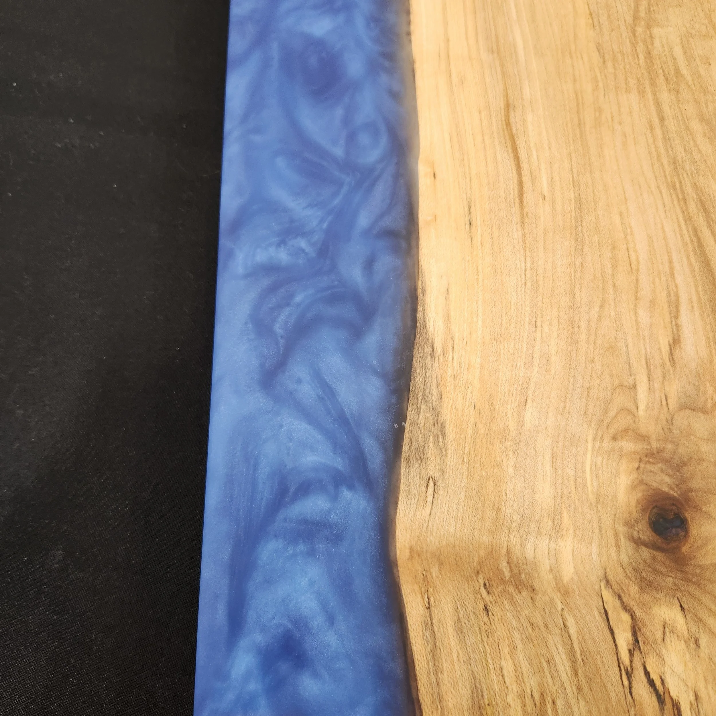 Close up of epoxy swirls of 16 x 9 Maple Wood Epoxy Charcuterie Board with Deep Blue Sea epoxy