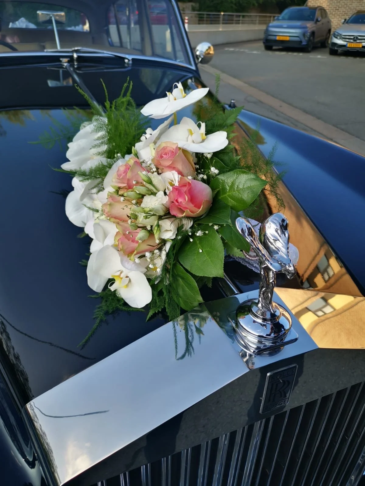 Rose, orchid, et fleurs blanches sur la calandre d'une voiture Rolls-Royce