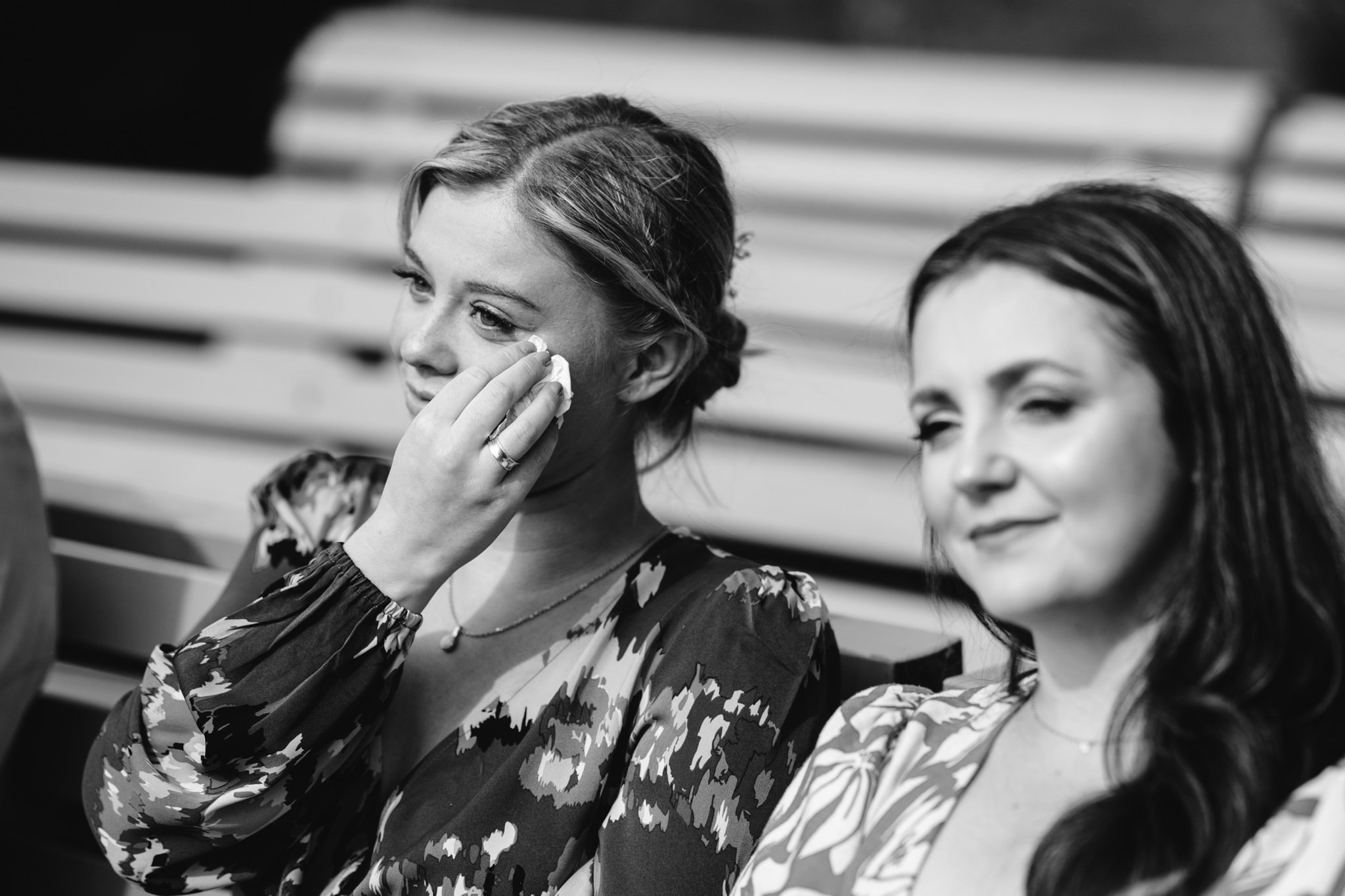 candid black and white photo of guest crying during outdoor ceremony