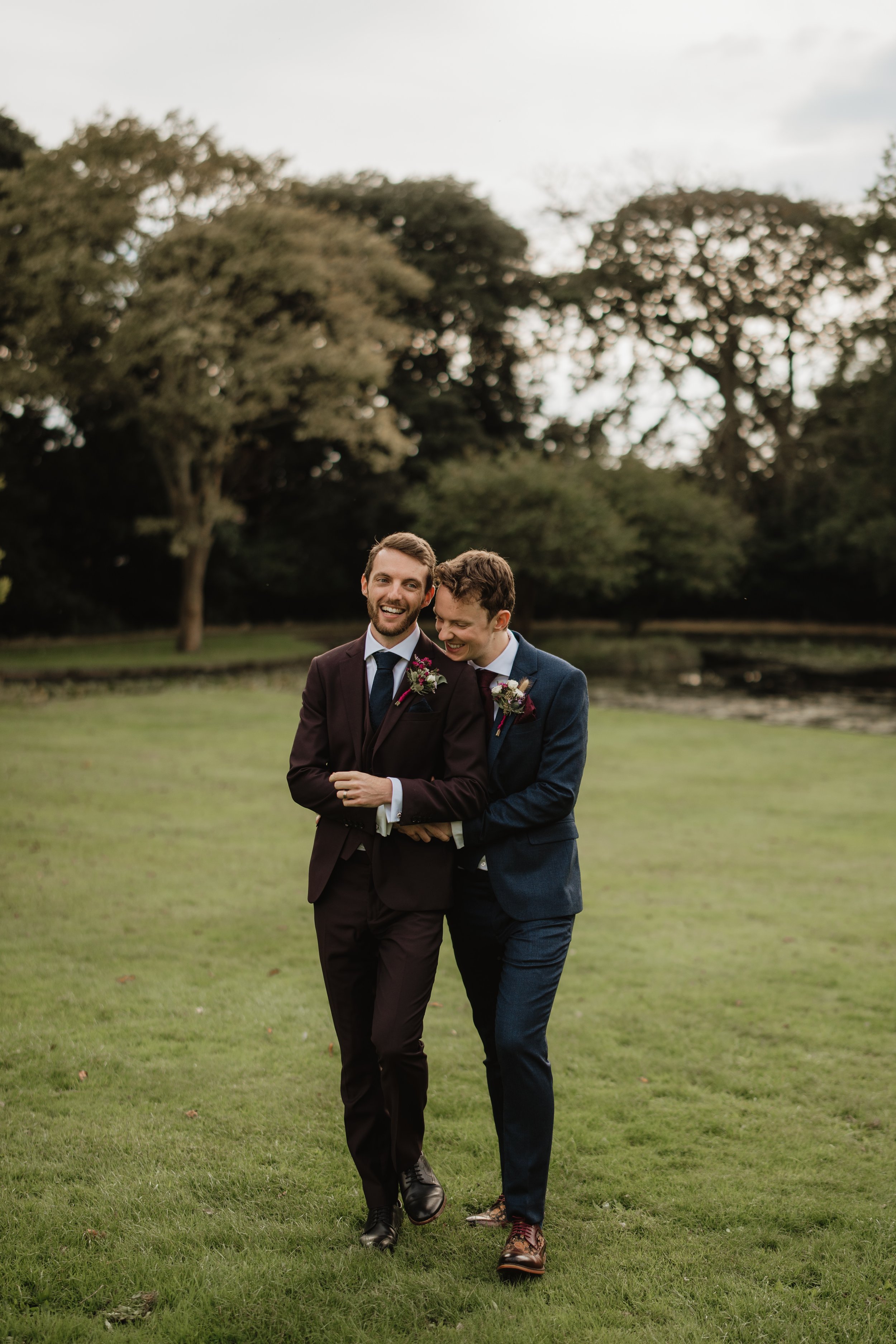 same sex couple hugging as they walk at clevedon hall