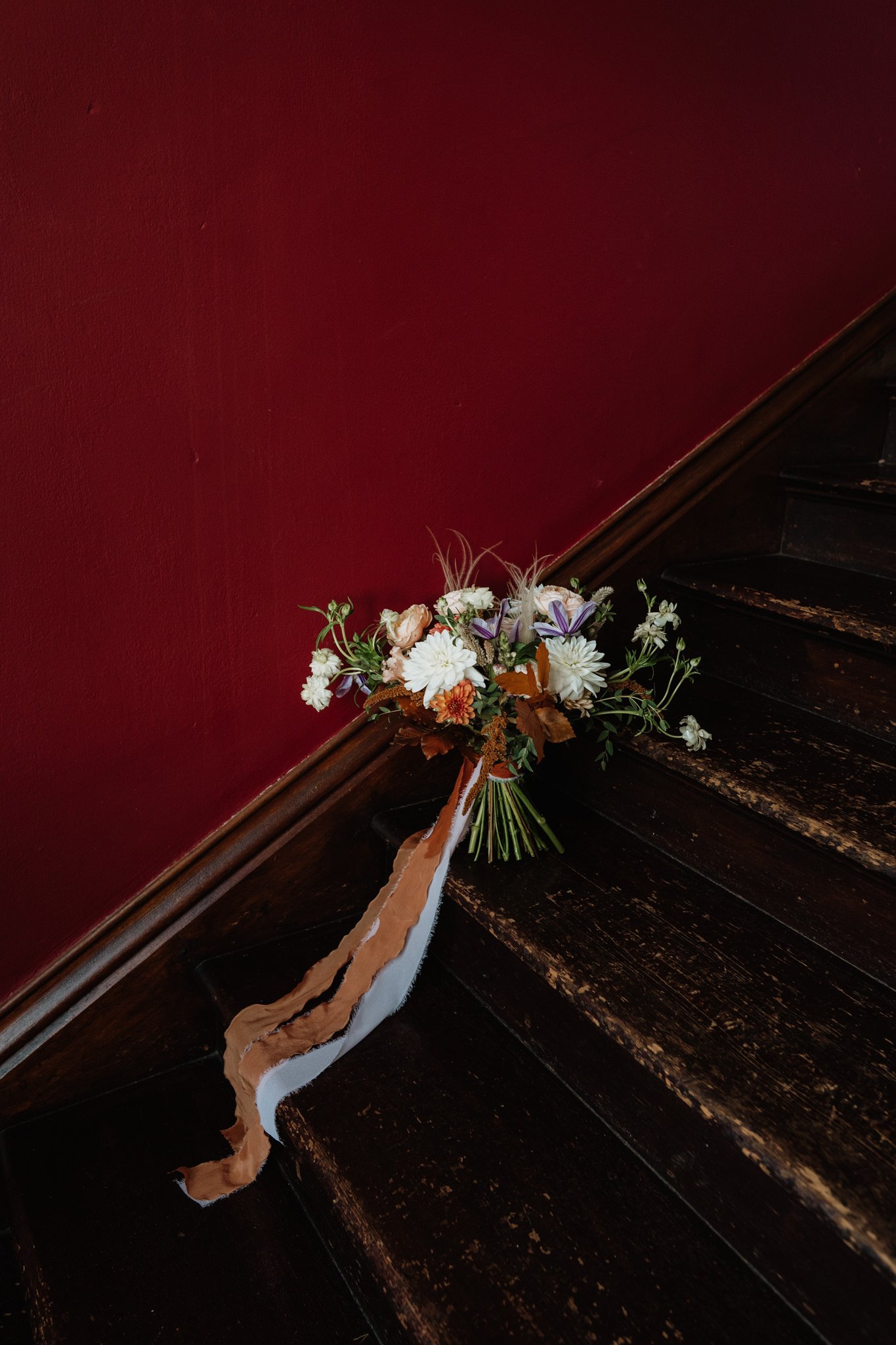 autumnal wedding bouquet on dark staircase