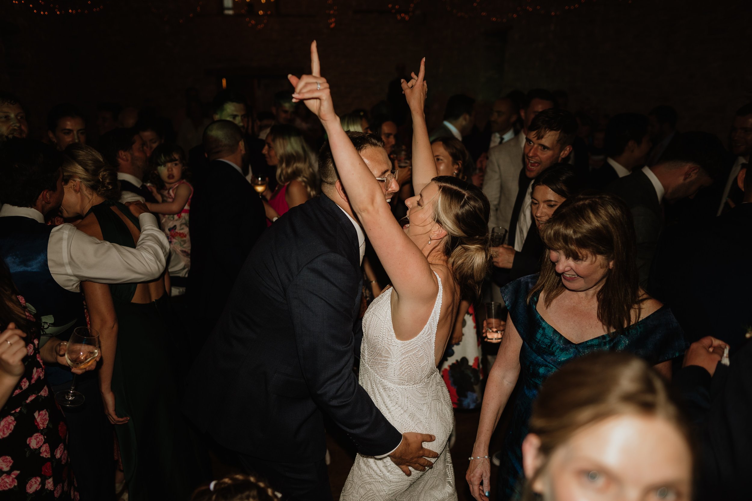bride and groom dancing, bride throwing her arms up in the air