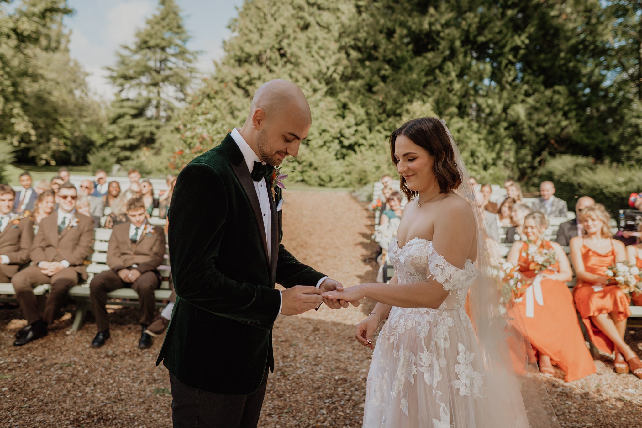 groom puts on brides ring during ceremony