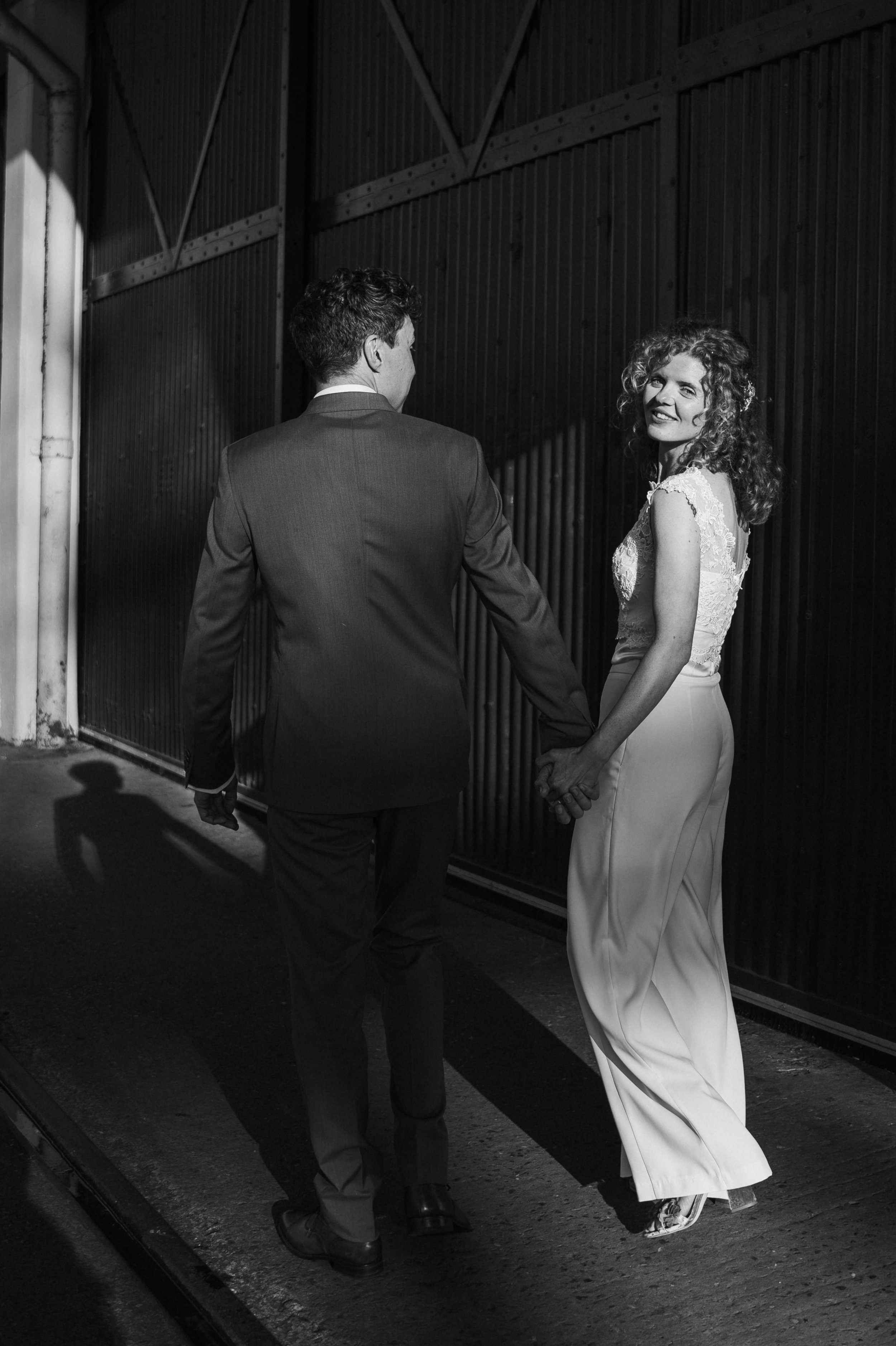 bride looks back at the camera while walking with the groom