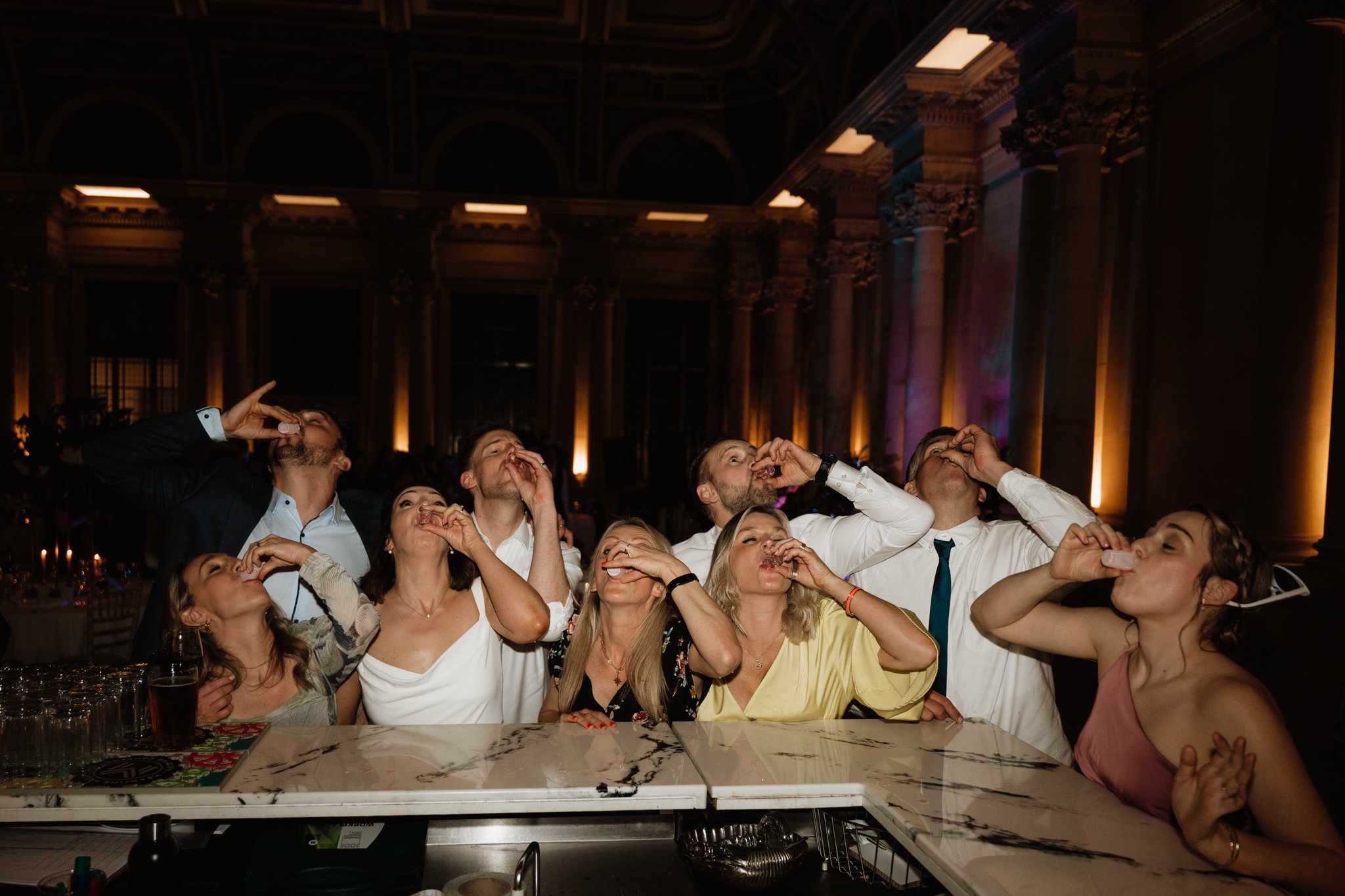 group of guests do a shot of tequila with the bride