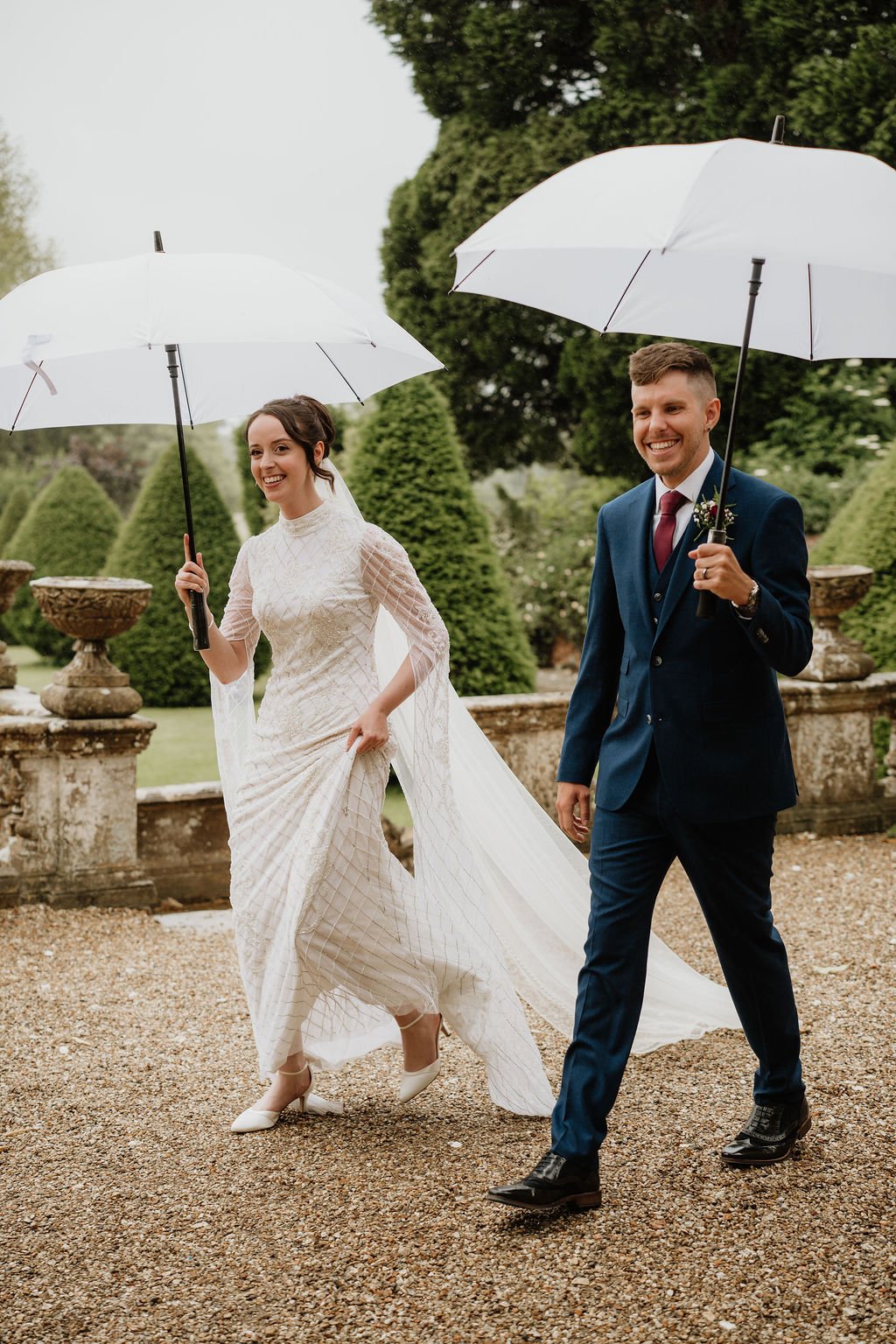 couple walking with umbrellas and laughing