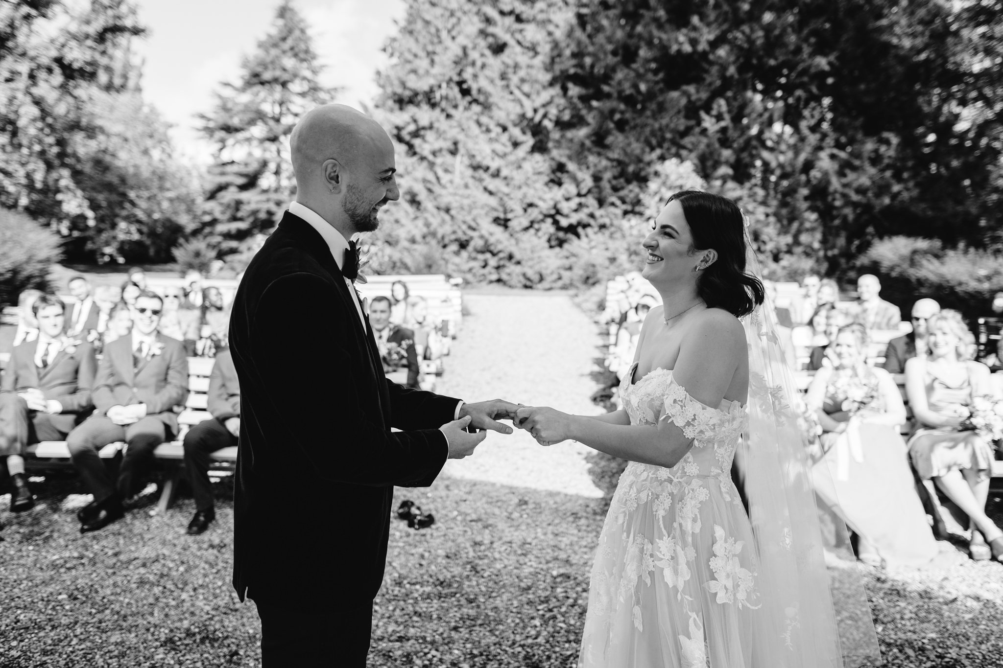 bride and groom exchanging rings black and white
