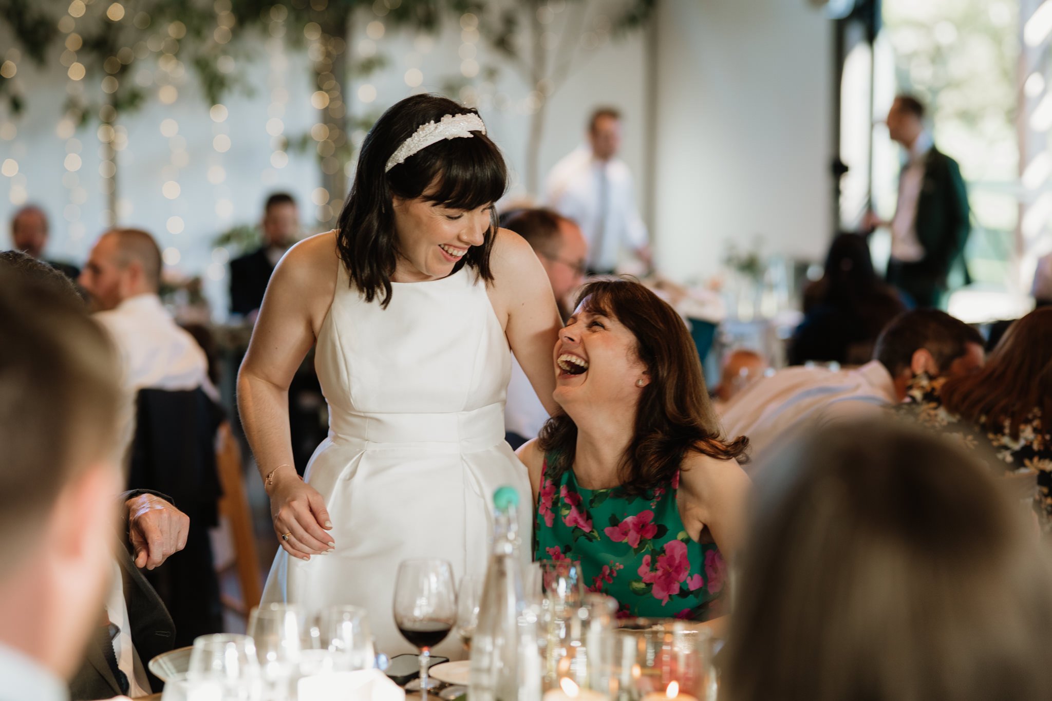 candid photo of bride laughing with wedding guest