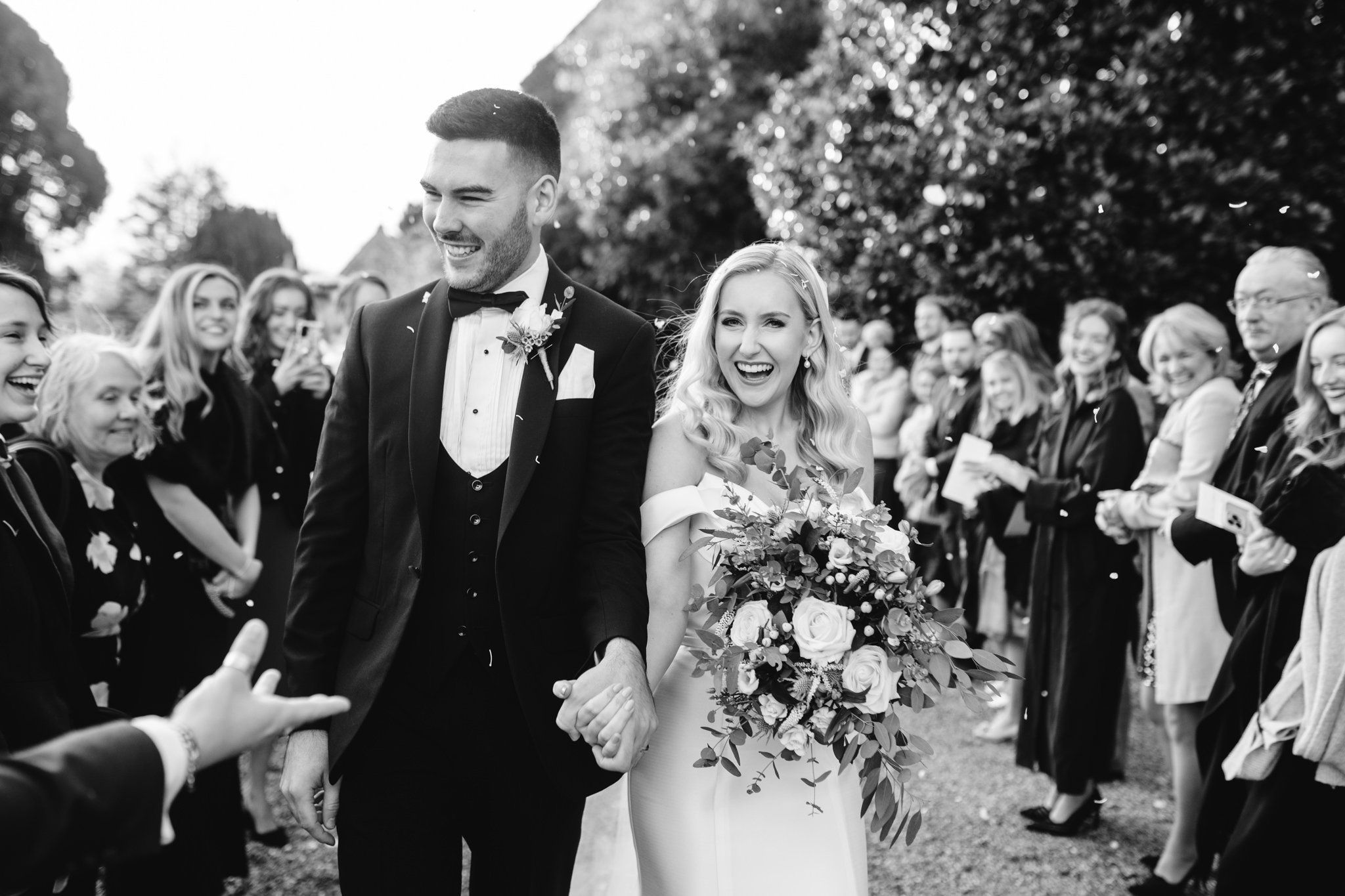bride and groom in black and white with confetti