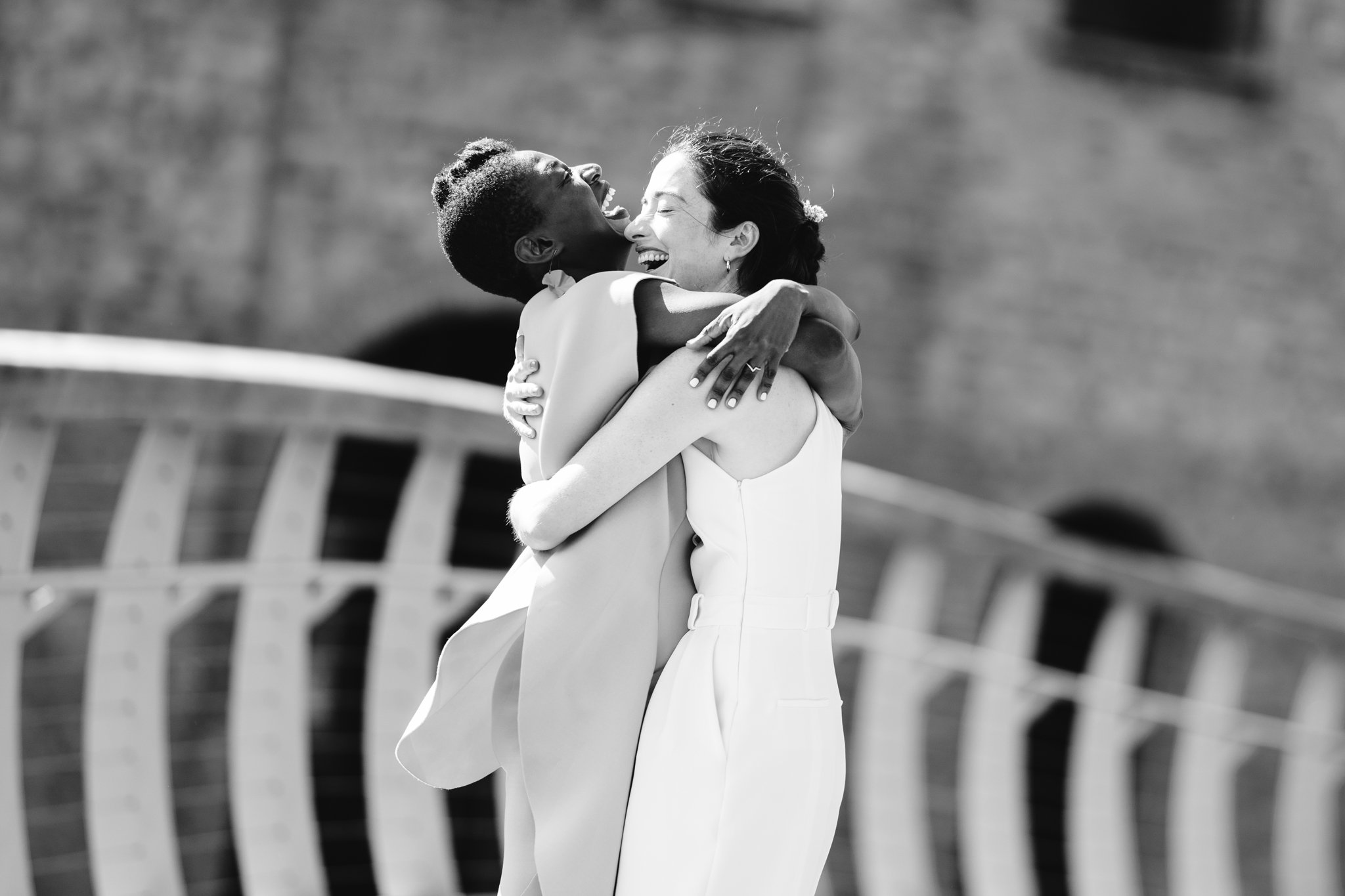 same sex couple hugging on bridge in bristol