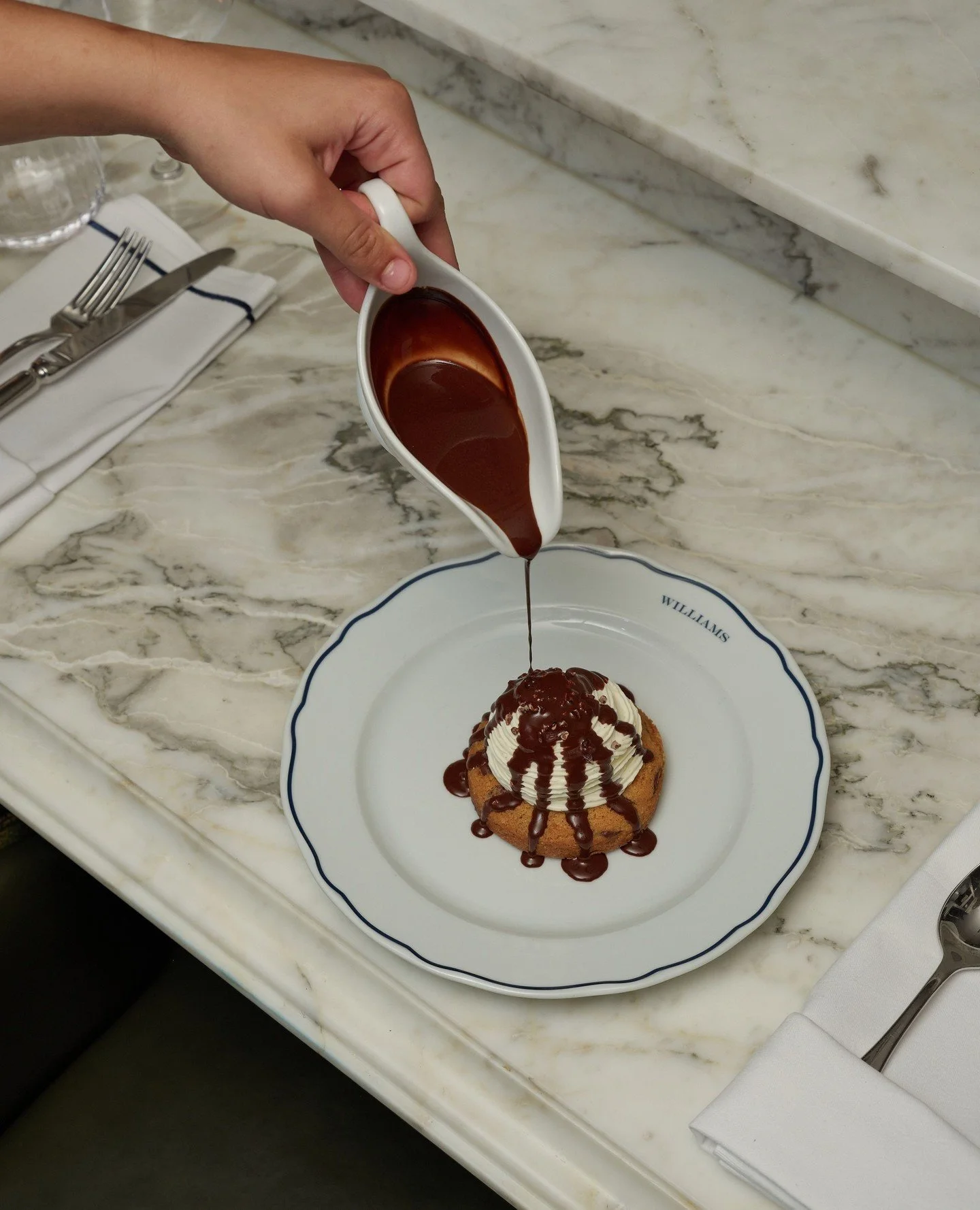 A warm chocolate chip cookie, light chantilly, and rich chocolate sauce poured just before it reaches the table. Simple, familiar, and exactly as comforting as it sounds.⁠
⁠
Book your table via the link in bio.