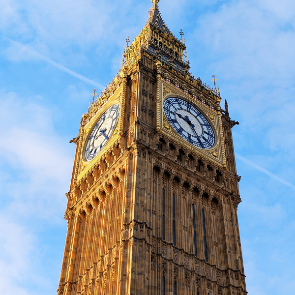 A close-up view of Big Ben clock tower with a clear blue sky in the background.