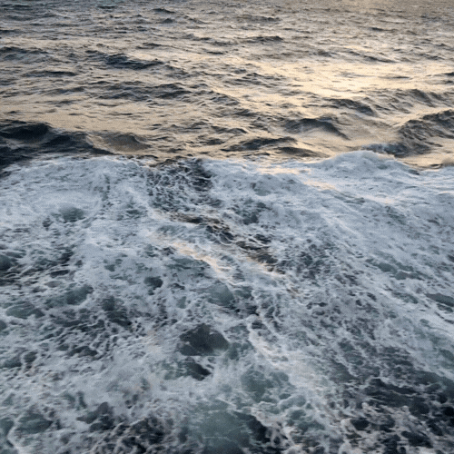Ocean water with waves at sunset or sunrise.