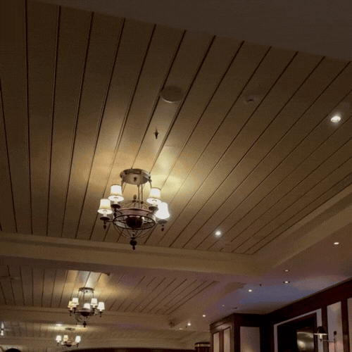 Ceiling with wooden panels, multiple chandeliers, and recessed lighting.