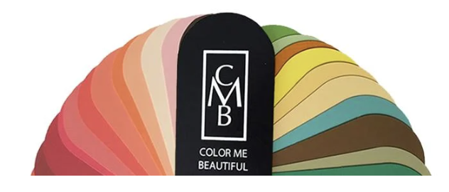 Sample color palette fan deck spread out on a wooden surface, showing various colors in a fan shape.