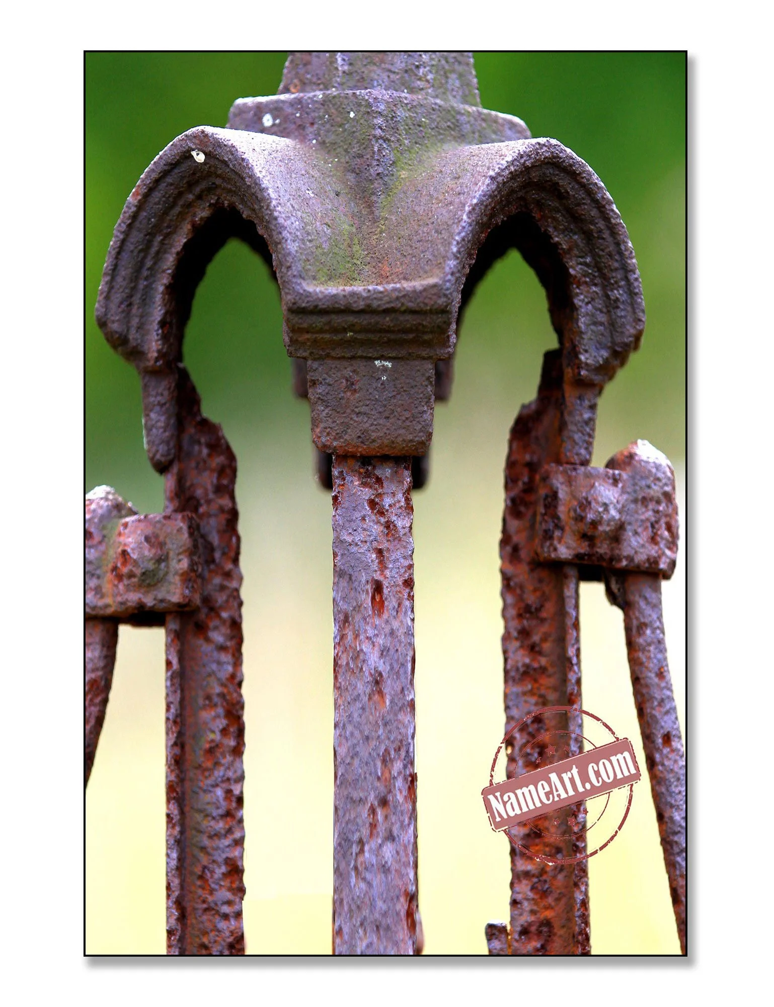 Close-up of a rusty, decorative wrought iron fence with a weathered, textured surface, and a background with a blurred green and yellow gradient.