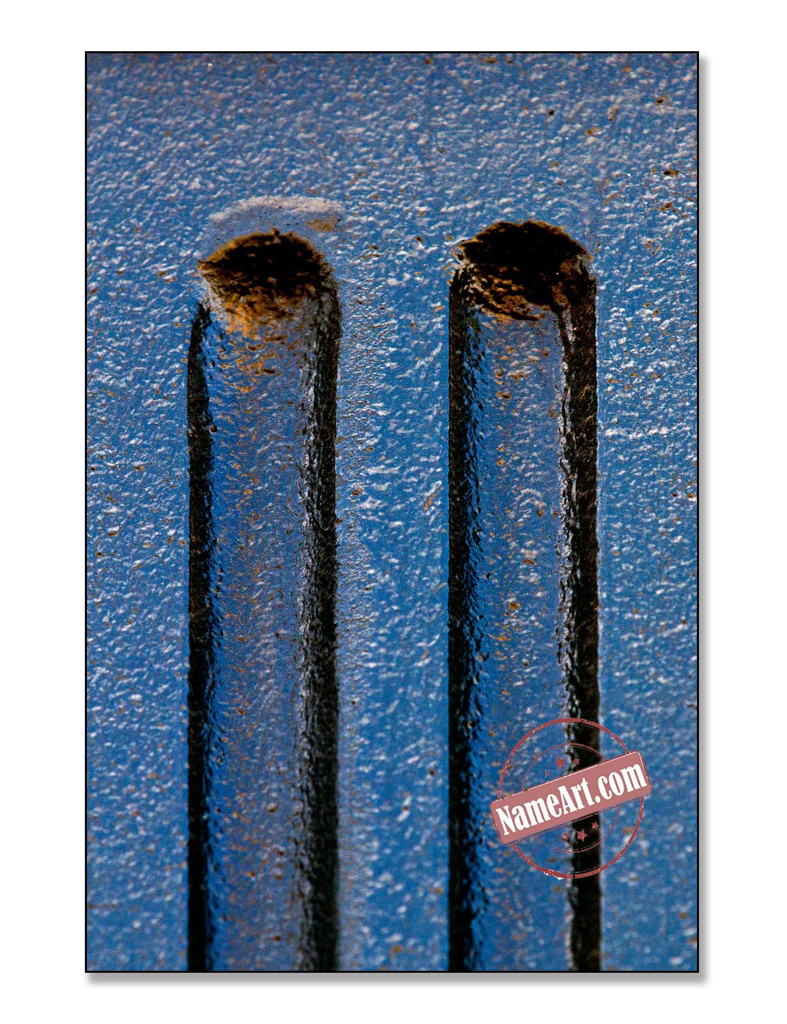 Close-up of two rusted metal nails on a textured blue surface.