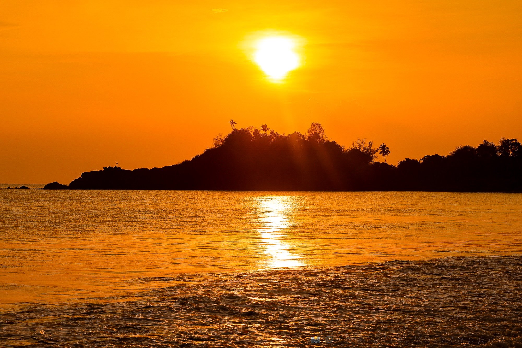 Sunset over the peninsula in Patnem Goa, covering the ocean in glimmering golden light