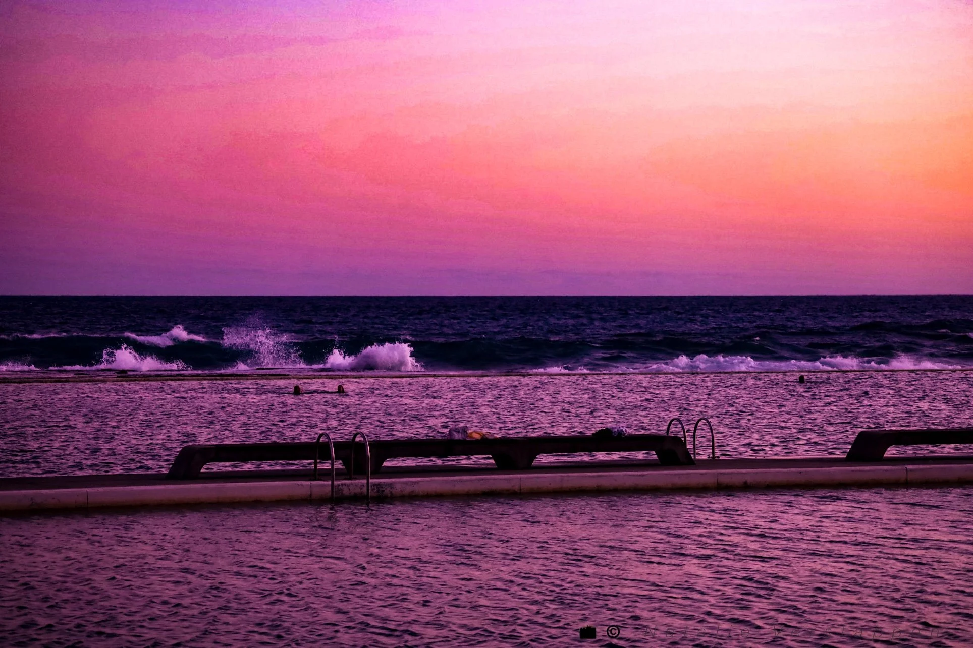 Pink sky over the ocean and a natural pool