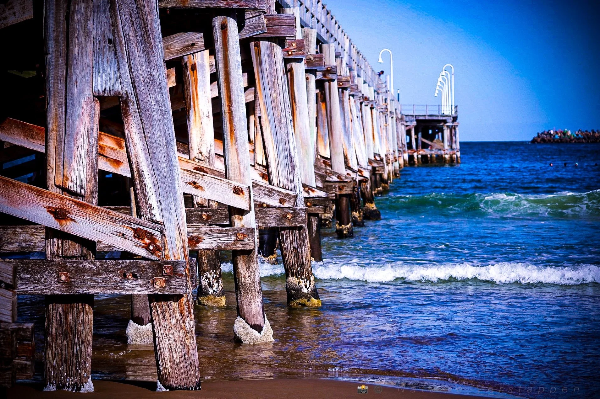 A pier heading into the ocean, blue perspective 
