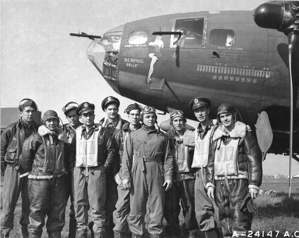 Members of the Memphis Belle crew standing in front of their B-17 bomber.