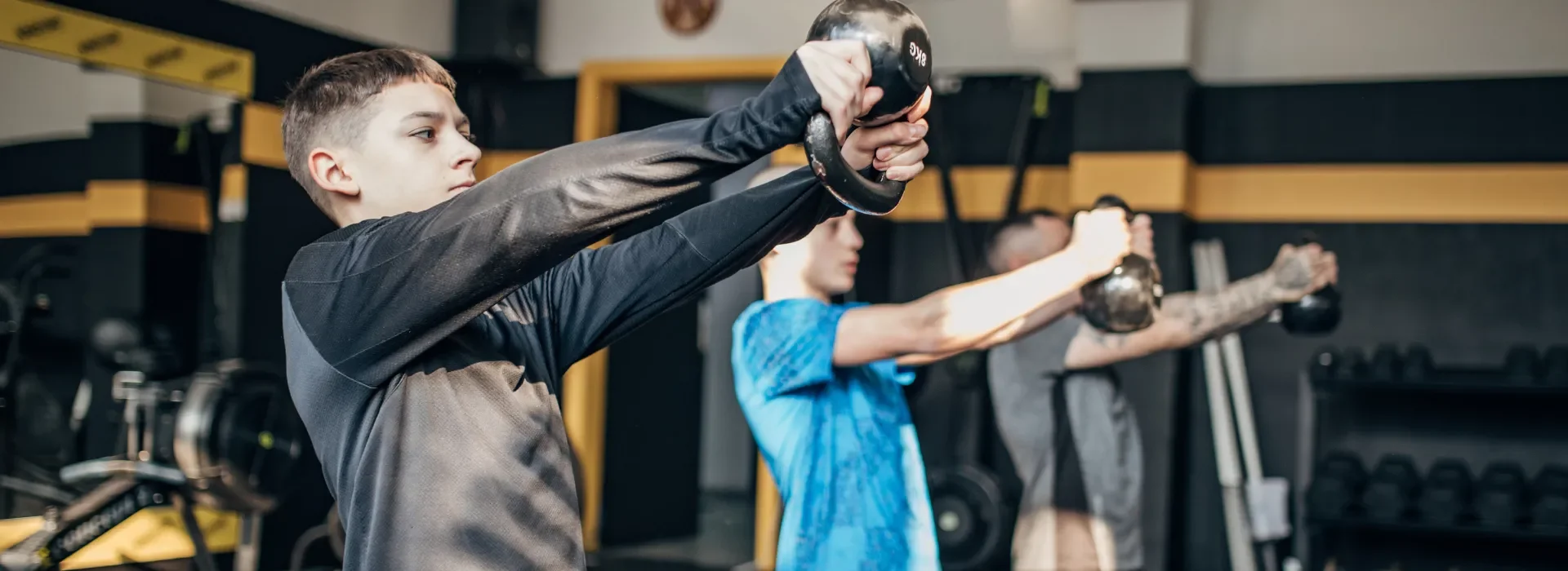 Youth training class with a boy lifting a kettlebell at Forge CHS - training youth athletes to be capable, comfortable, confident in West Ashley, Charleston, SC