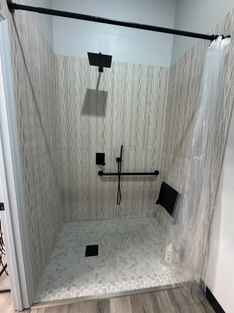 Private shower with rainfall head and matte black fixtures at Forge CHS gym in West Ashley Charleston SC