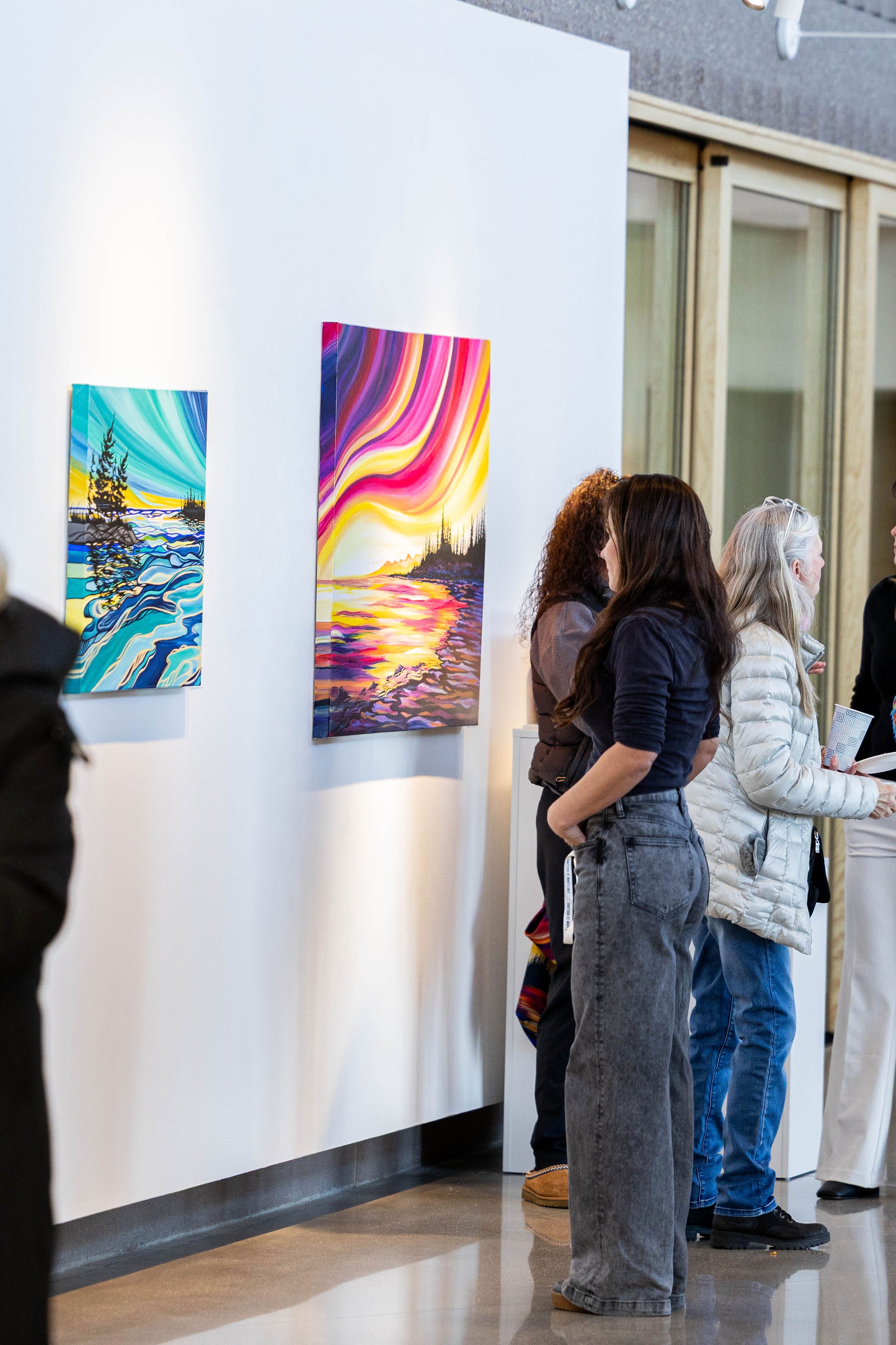 a woman looking at colorful art in the RiverPlace gallery