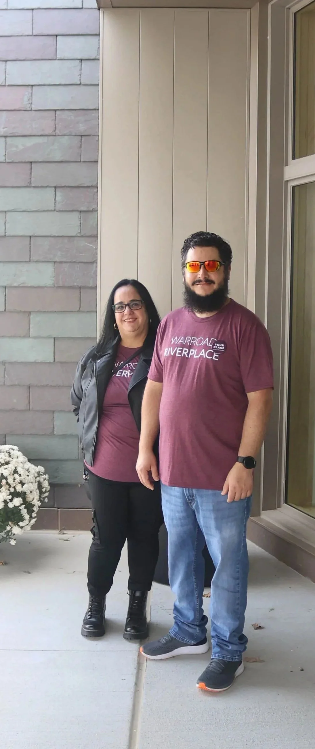 a photo of a man and a woman standing in front of RiverPlace wearing RiverPlace t-shirts