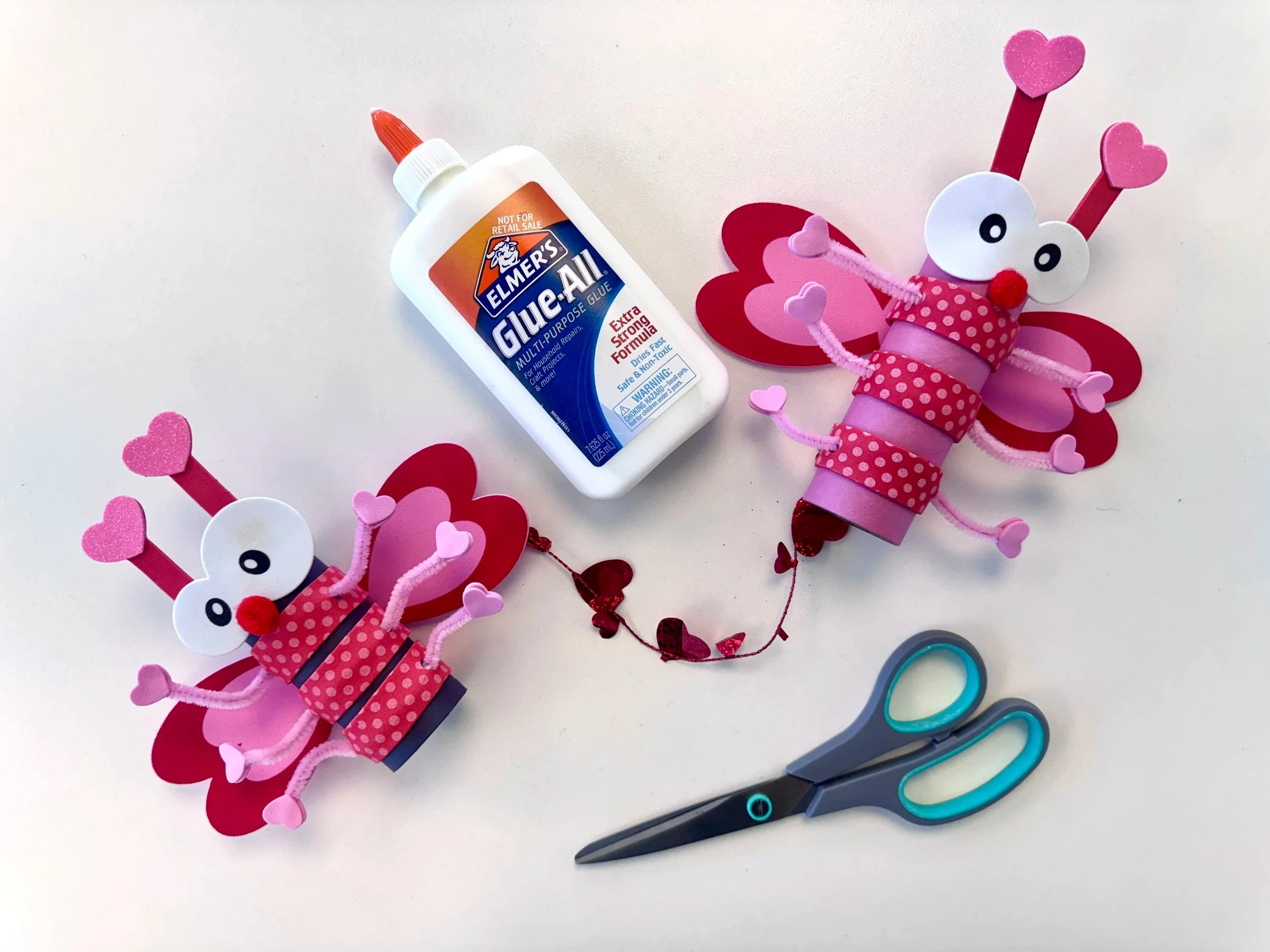 pink and red "love bug" crafts by scissors and glue bottle