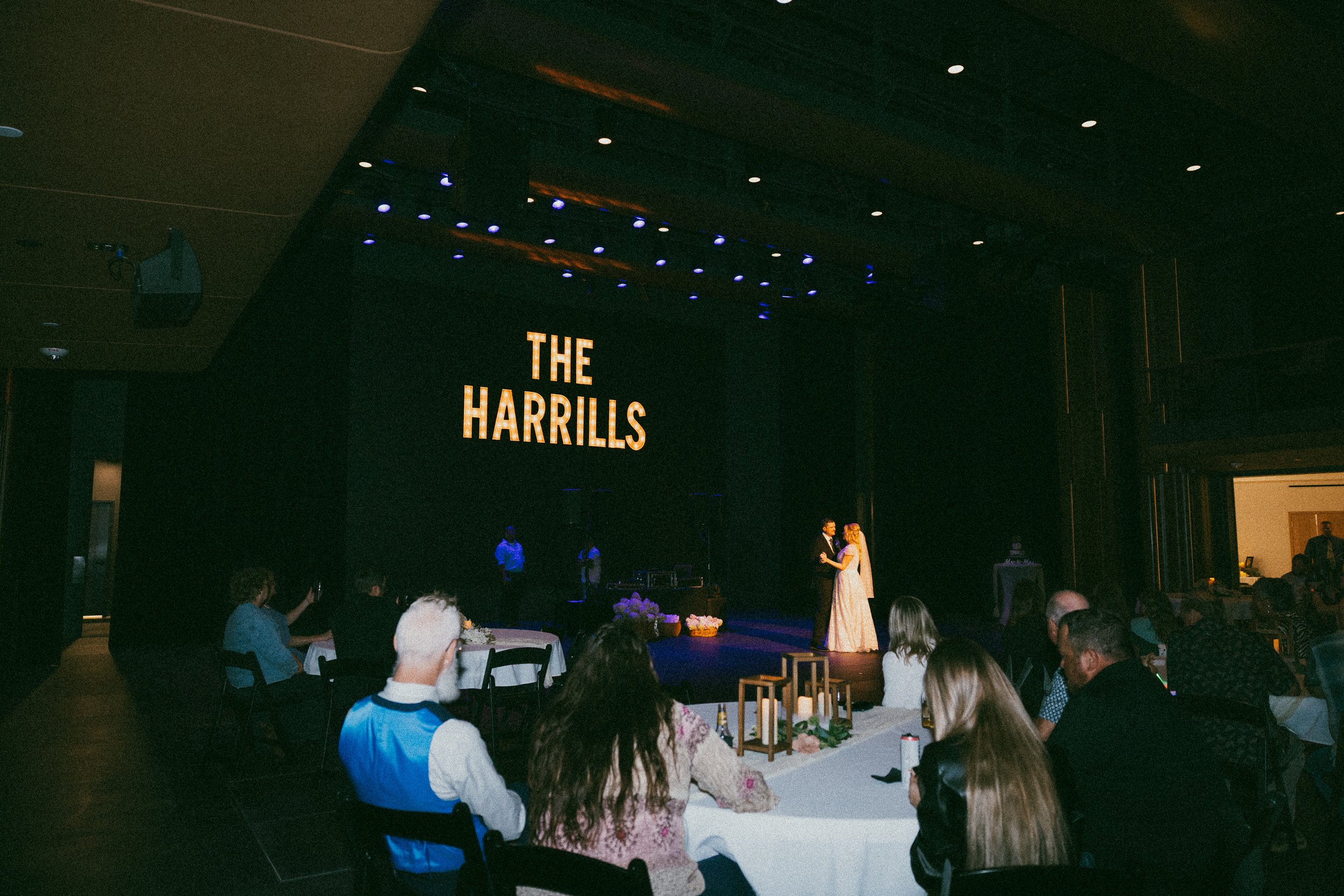 A wedding at RiverPlace in the performance hall with a couple dancing and people looking on.
